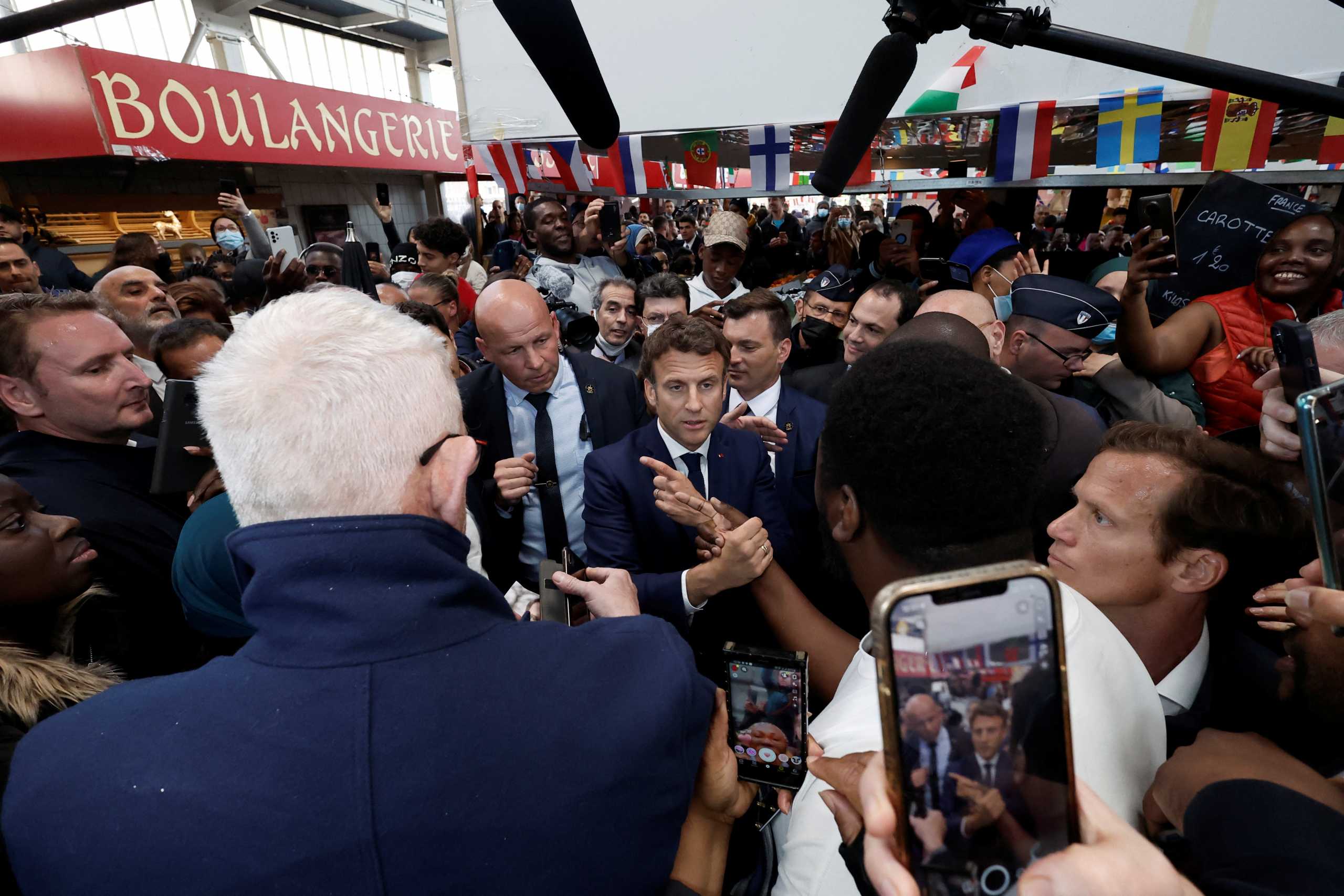 French President Emmanuel Macron meets with residents and vendors at the Saint-Christophe market square in Cergy, Paris suburb, during his first trip after being re-elected president, France, April 27, 2022. REUTERS