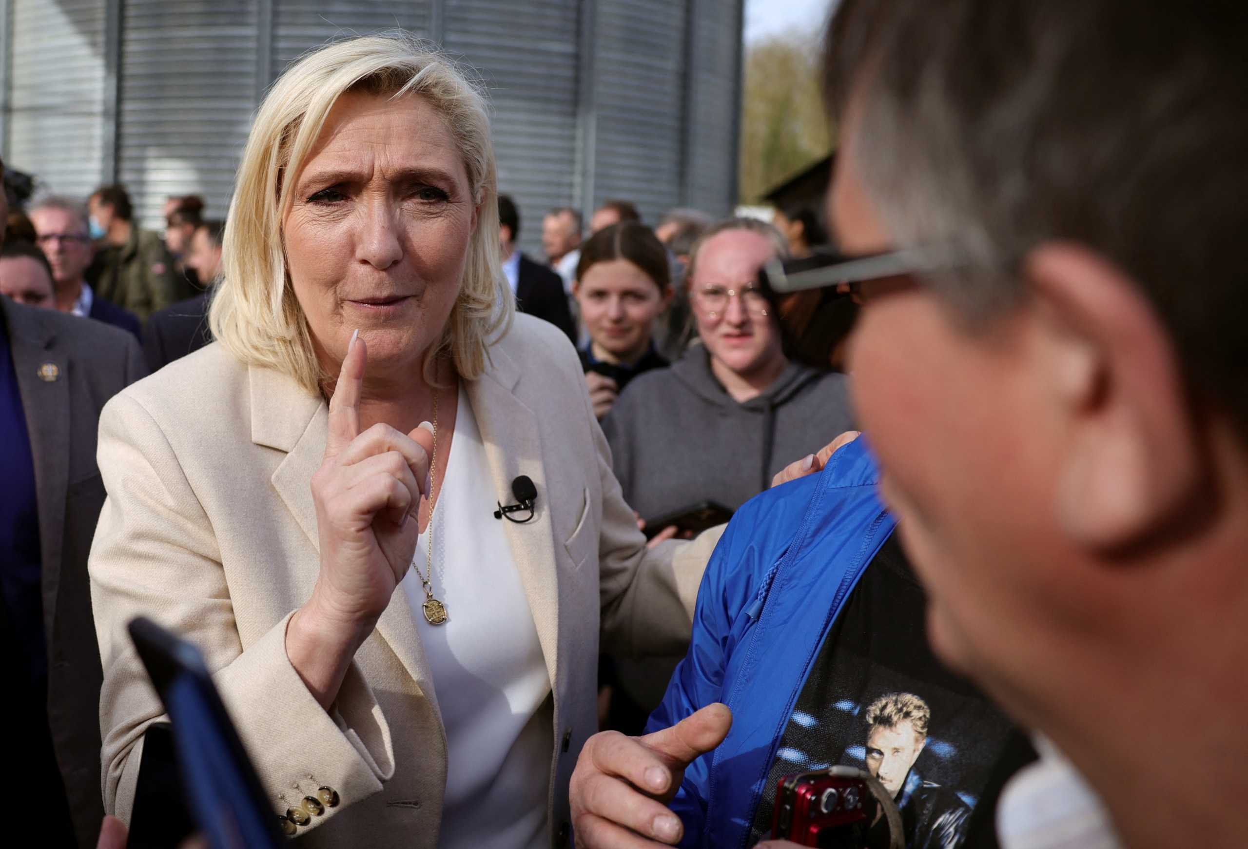 Marine Le Pen, French far-right National Rally (Rassemblement National) party candidate for the 2022 French presidential election, talks with a supporter, as she campaigns the day after the first round of the 2022 French presidential election where Le Pen ended in second place, in Soucy, France, April 11, 2022. REUTERS