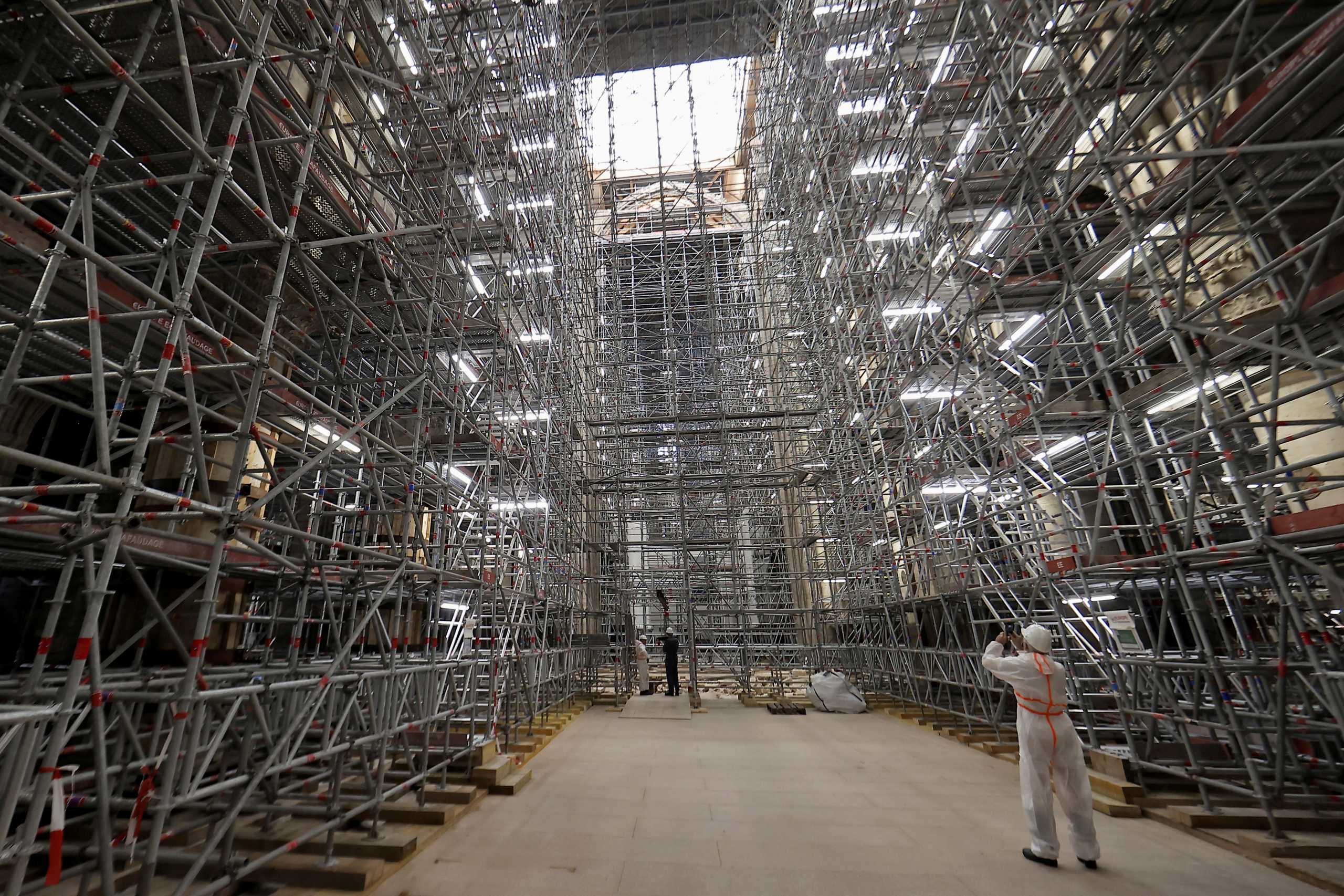 A workman takes a picture of the scaffolding's at the reconstruction site ahead a visit of the French President Emmanuel Macron at the Notre-Dame de Paris Cathedral, which was damaged in a devastating fire three years ago, as restoration works continue, in Paris, France, April 15, 2022. Ian Langsdon