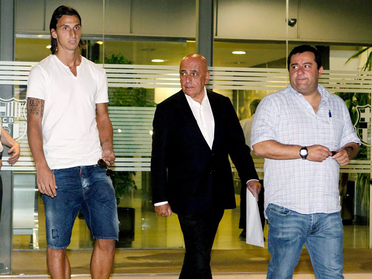 epa02305243 Swedish forward Zlatan Ibrahimovic (L) walks with AC Milan vice president Adriano Galiani (C) and Ibrahimovic's agent Mino Raiola (R) at FC Barcelona headquarters in Barcelona, eastern Spain, 28 August 2010. AC Milan have signed Sweden forward Zlatan Ibrahimovic from Barcelona for 24 million euros, the Italian club announced on August 28.  EPA