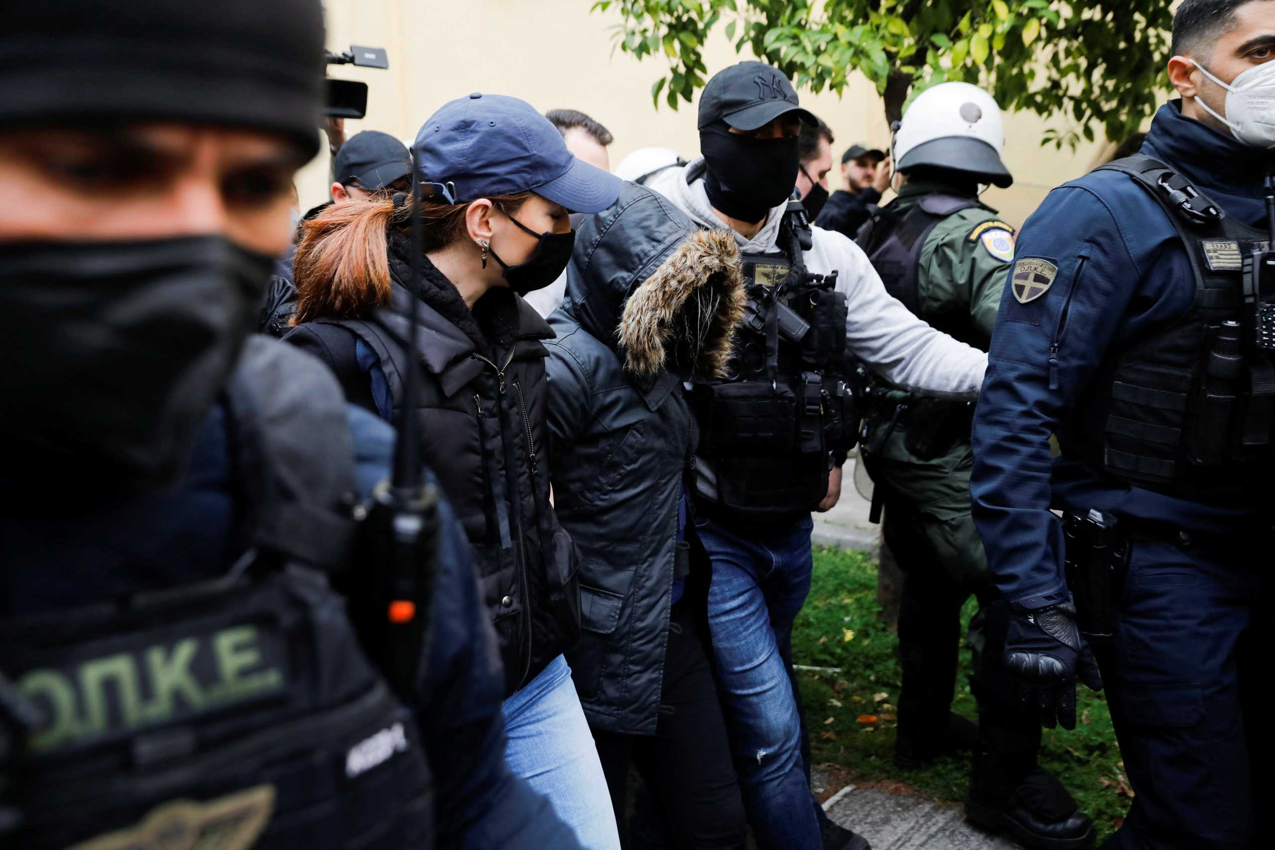 Α 33-years-old Greek woman, who is charged with killing of her 9-year-old daughter, is escorted by police officers to the prosecutors office, in Athens, Greece, March 31, 2022. REUTERS