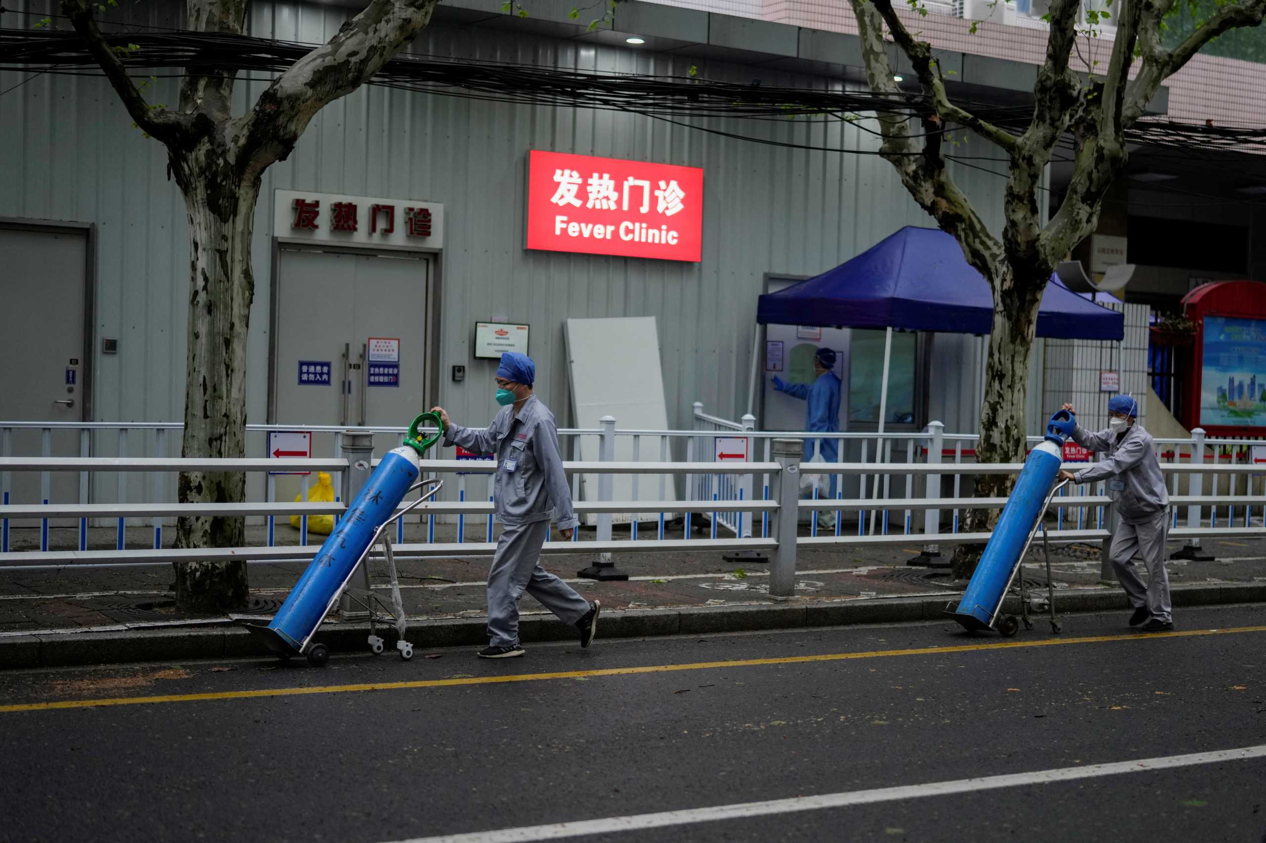 Workers deliver oxygen cylinders outside a hospital during lockdown amid the coronavirus disease (COVID-19) pandemic, in Shanghai, China April 14, 2022. REUTERS