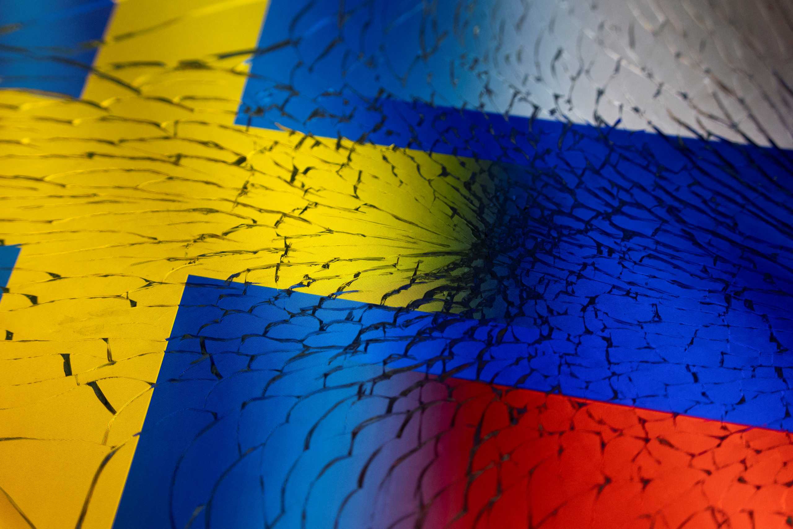 Swedish and Russian flags are seen through broken glass this illustration taken April 13, 2022. REUTERS