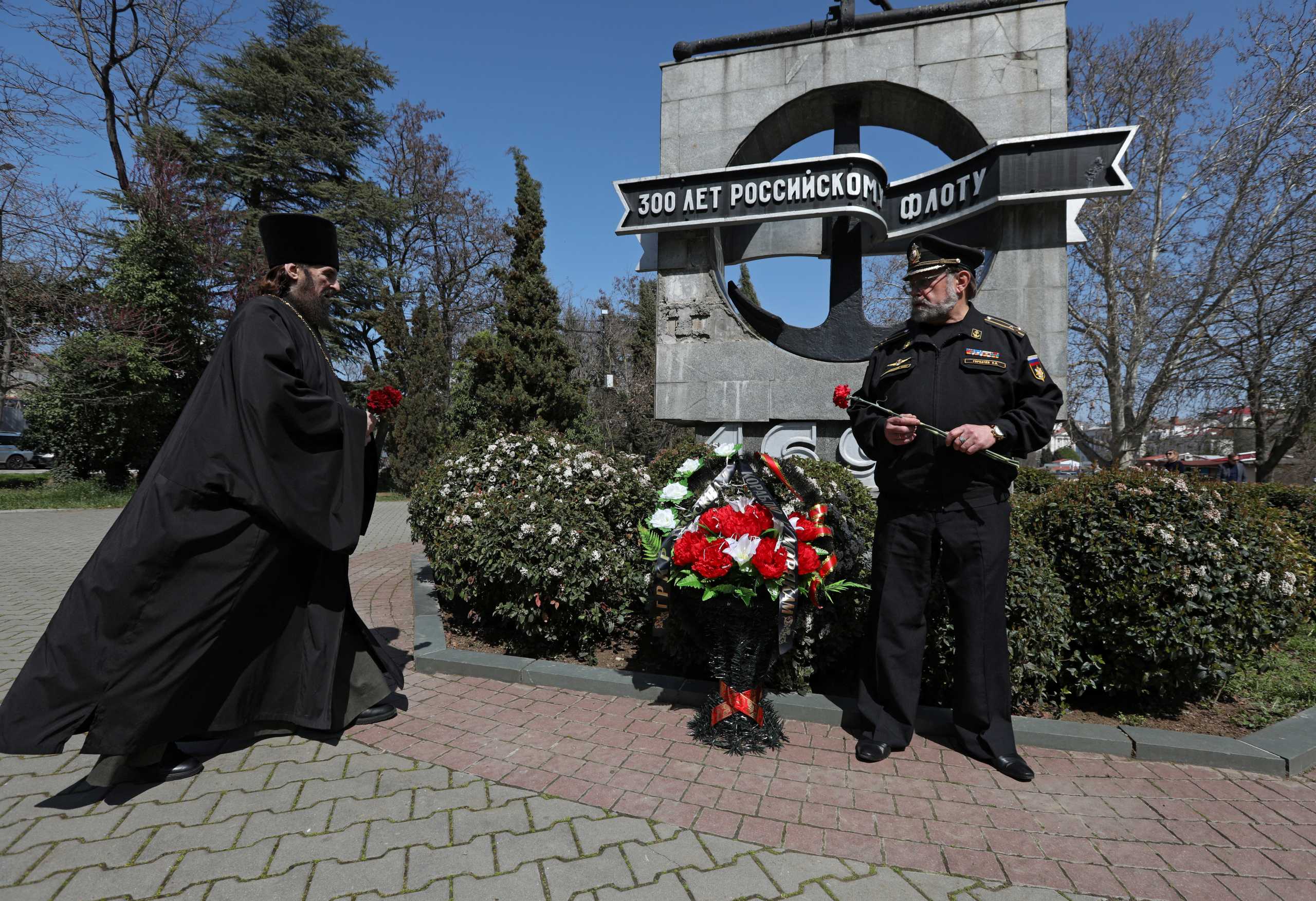 Veteran of the Black Sea Fleet Sergei Gorbachev and an Orthodox priest take part in a ceremony organised by the veterans in memory of the Russian missile cruiser Moskva, which sank in the Black Sea following a fire, in Sevastopol, Crimea April 15, 2022. REUTERS