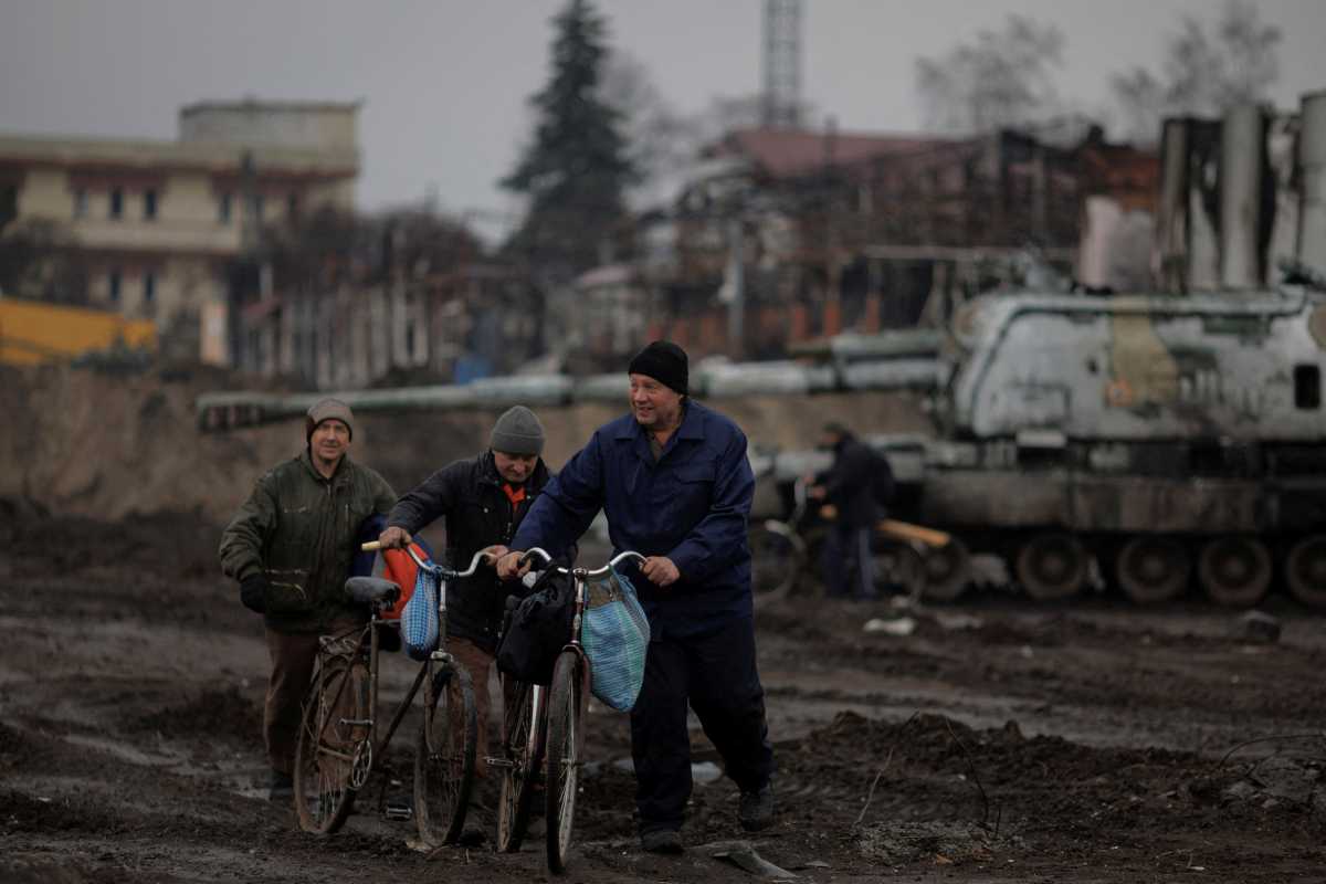 Locals walk in the demolished town center of Trostyanets after Ukrainian forces expelled Russian troops from the town which Russia had occupied at the beginning of its war with Ukraine, March 30, 2022.  REUTERS