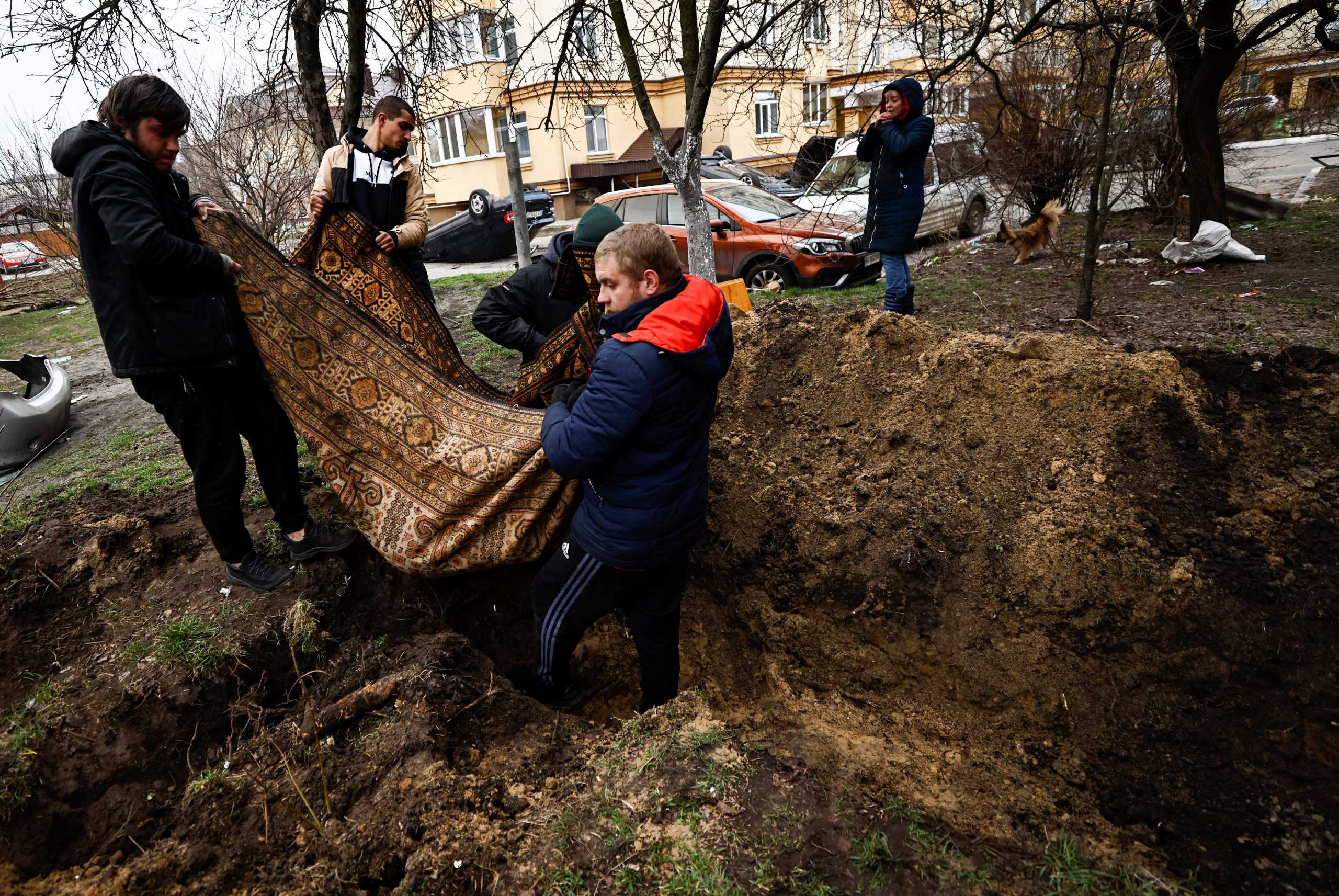Sergey Lagovskiv, 26, and other residents carry the body of Igor Lytvynenko, who according to residents was killed by Russian Soldiers, after they found him beside a building's basement, to bury him at the garden of residential building, amid Russia's invasion on Ukraine, in Bucha, Ukraine April 5, 2022. REUTERS