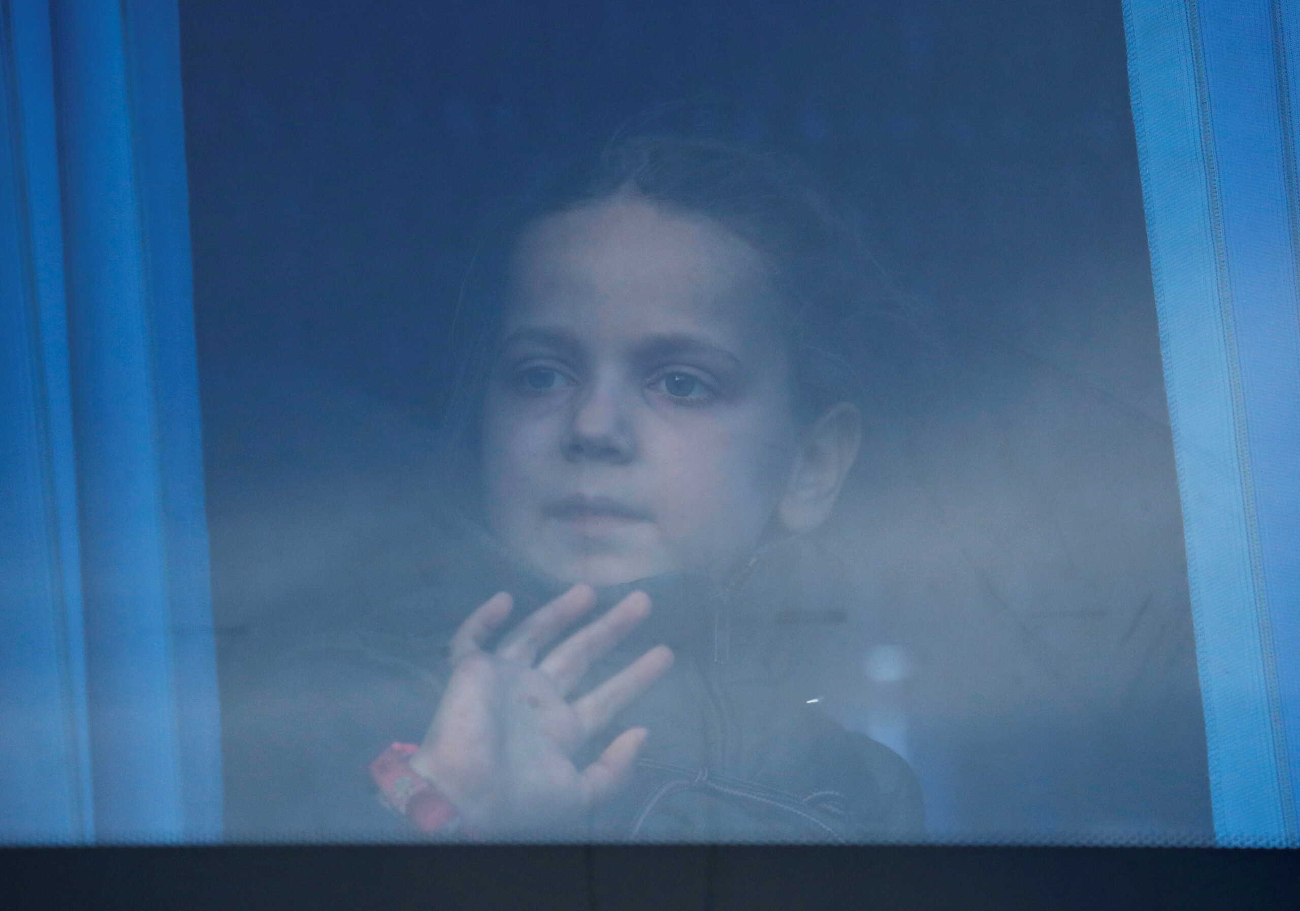 A girl looks trhrough the bus window as civilians evacuated from Azovstal steel plant in Mariupol arrive at a temporary accommodation centre in the village of Bezimenne, during Ukraine-Russia conflict in the Donetsk Region, Ukraine May 6, 2022. REUTERS