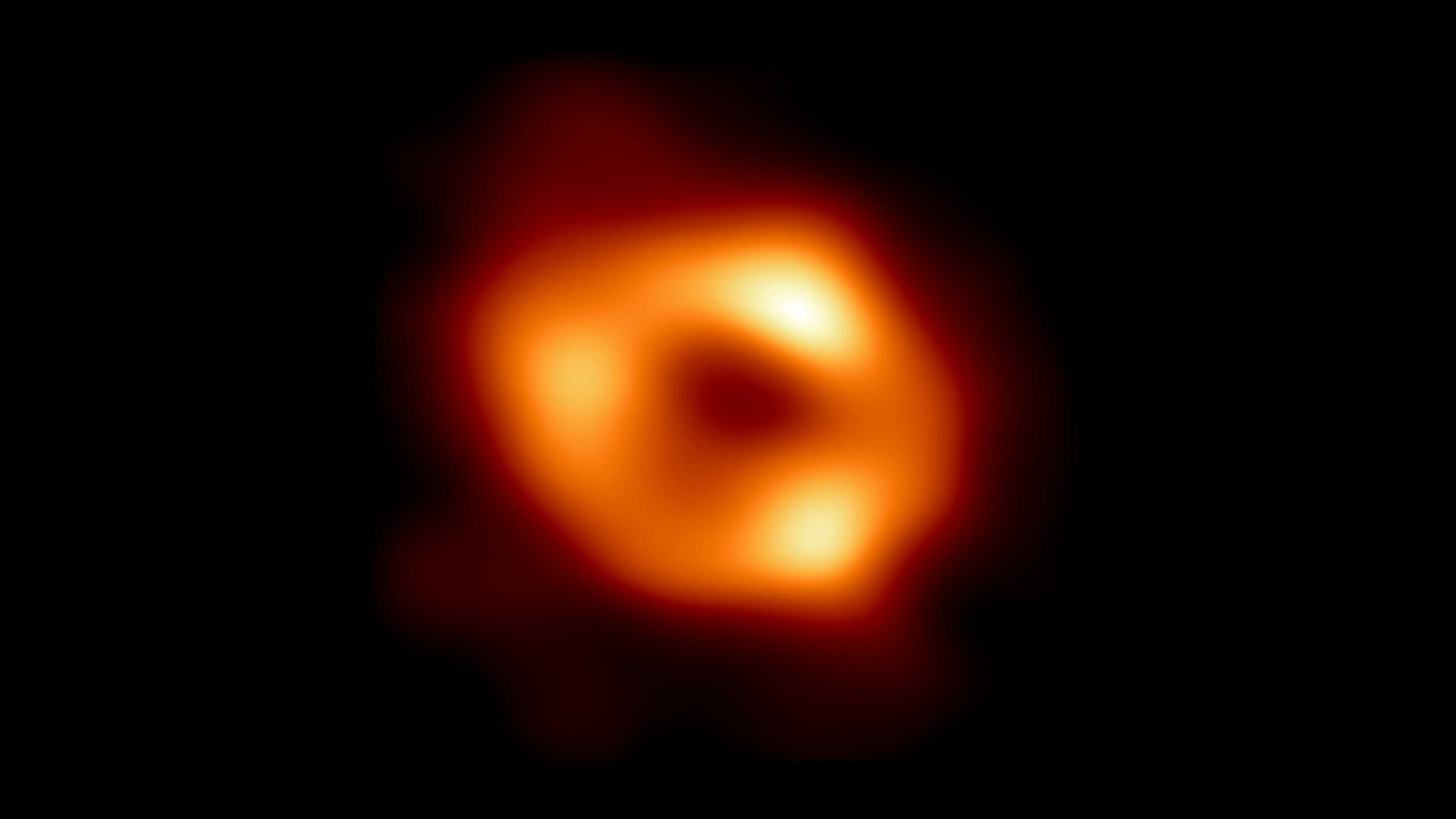 This is the first image of Sagittarius A* (or Sgr A* for short), the supermassive black hole at the center of our galaxy. It was captured by the Event Horizon Telescope (EHT), an array which linked together radio observatories across the planet to form a single "Earth-sized" virtual telescope. The new view captures light bent by the powerful gravity of the black hole, which is four million times more massive than our Sun.  EHT Collaboration