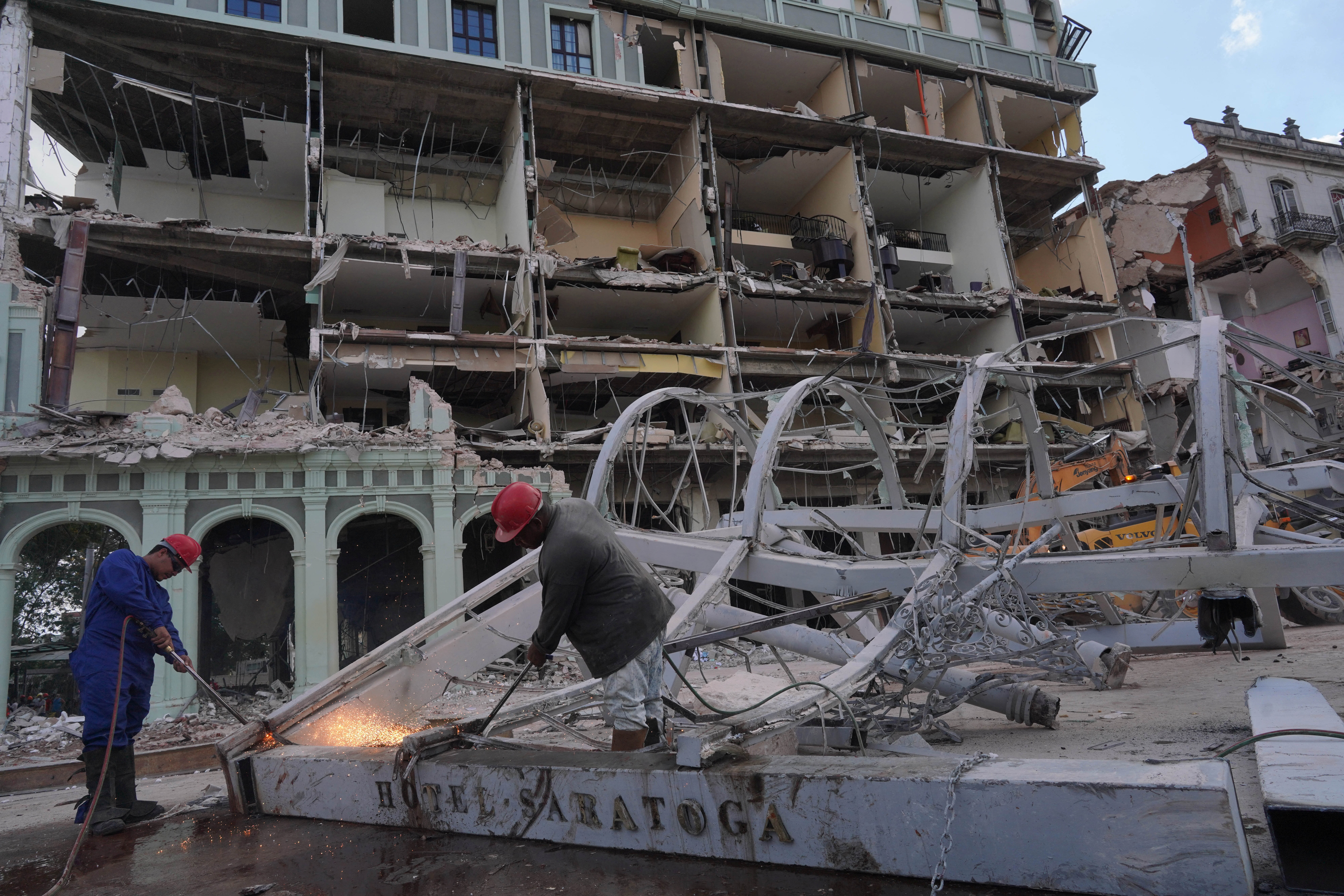 Workers weld metal debris in front of the Saratoga Hotel a day after it suffered an explosion, in Havana, Cuba May 7, 2022. REUTERS