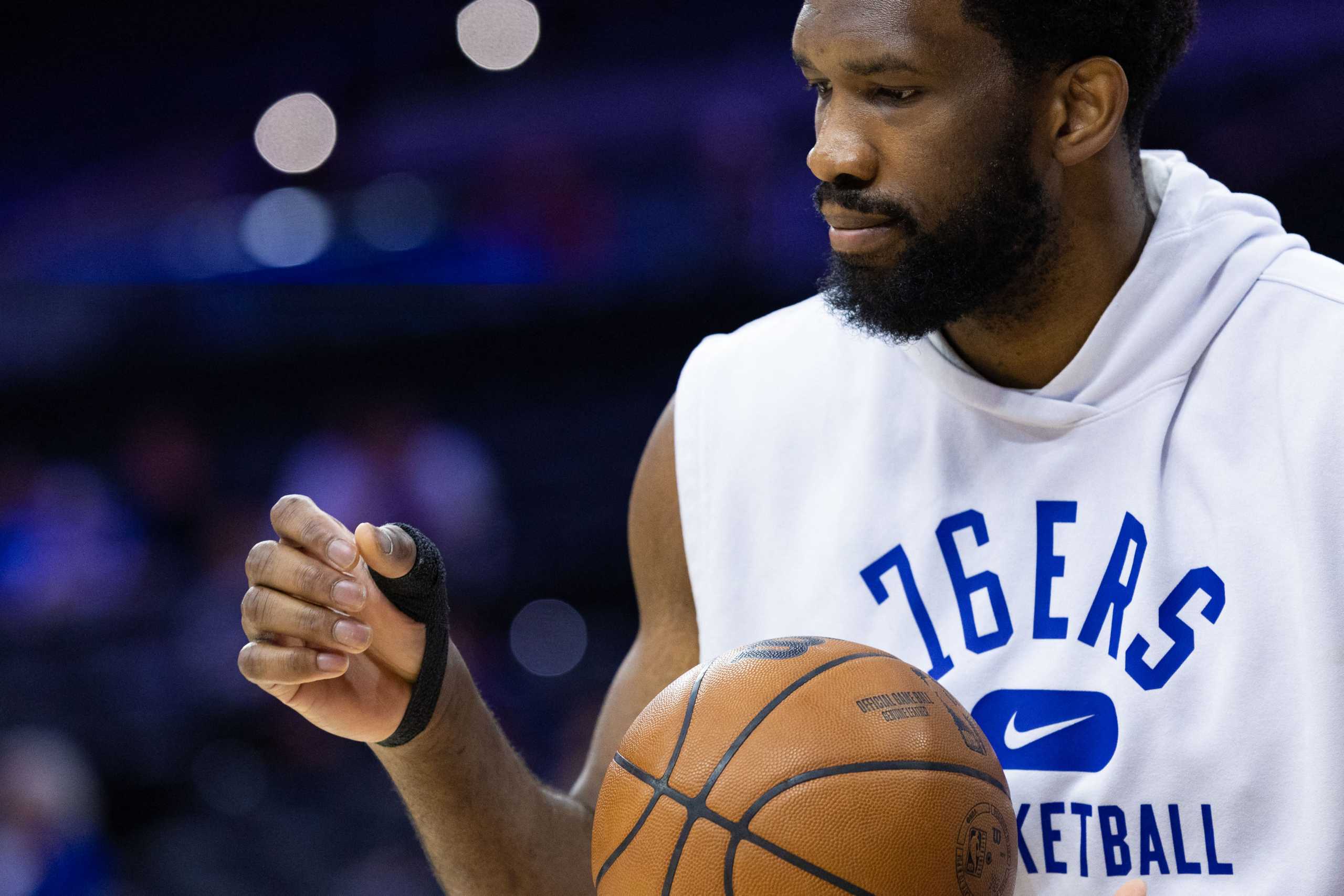 Apr 25, 2022; Philadelphia, Pennsylvania, USA; Philadelphia 76ers center Joel Embiid looks at his taped injured thumb before game five of the first round for the 2022 NBA playoffs against the Toronto Raptors at Wells Fargo Center. Mandatory Credit: Bill Streicher-USA TODAY Sports