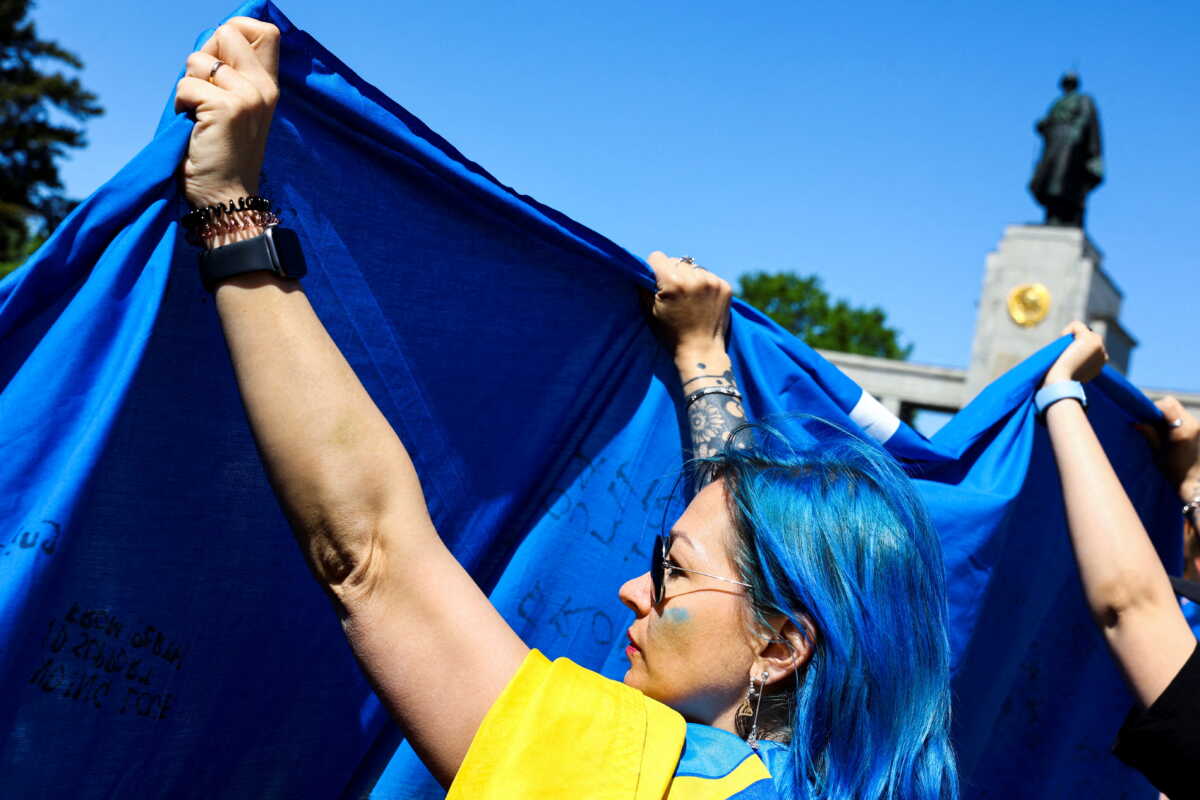 Activists unfold a Ukrainian flag during a wreath-laying ceremony organized by the Ukrainian Embassy to mark Victory Day and the 77th anniversary of the end of World War Two, at the Soviet War Memorial at Tiergarten Park in Berlin, Germany May 8, 2022. REUTERS