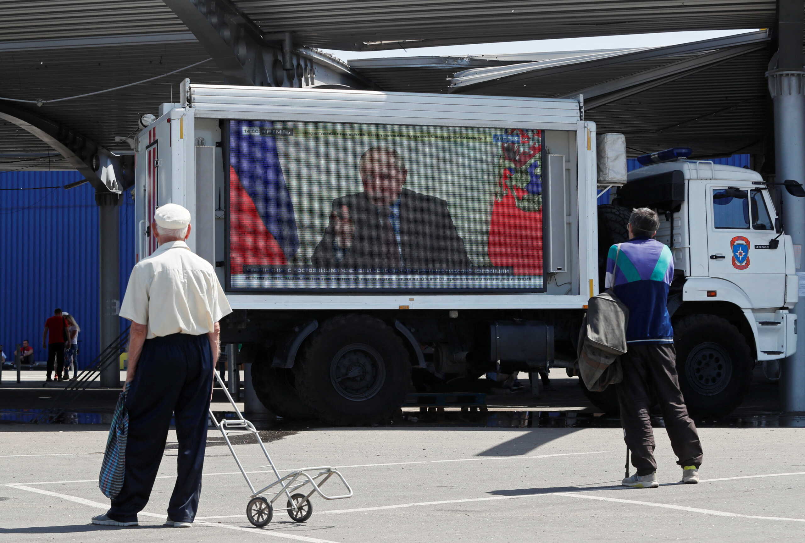 Russian President Vladimir Putin is seen on a screen broadcasting Russian TV news programs at a humanitarian aid distribution point during Ukraine-Russia conflict in the southern port city of Mariupol, Ukraine May 30, 2022. REUTERS