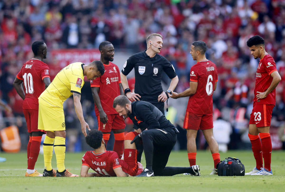 Soccer Football - FA Cup - Final - Chelsea v Liverpool - Wembley Stadium, London, Britain - May 14, 2022 Liverpool's Mohamed Salah receives medical attention after sustaining an injury as referee Craig Pawson, Liverpool's Thiago Alcantara and Chelsea's Thiago Silva look on Action Images via Reuters