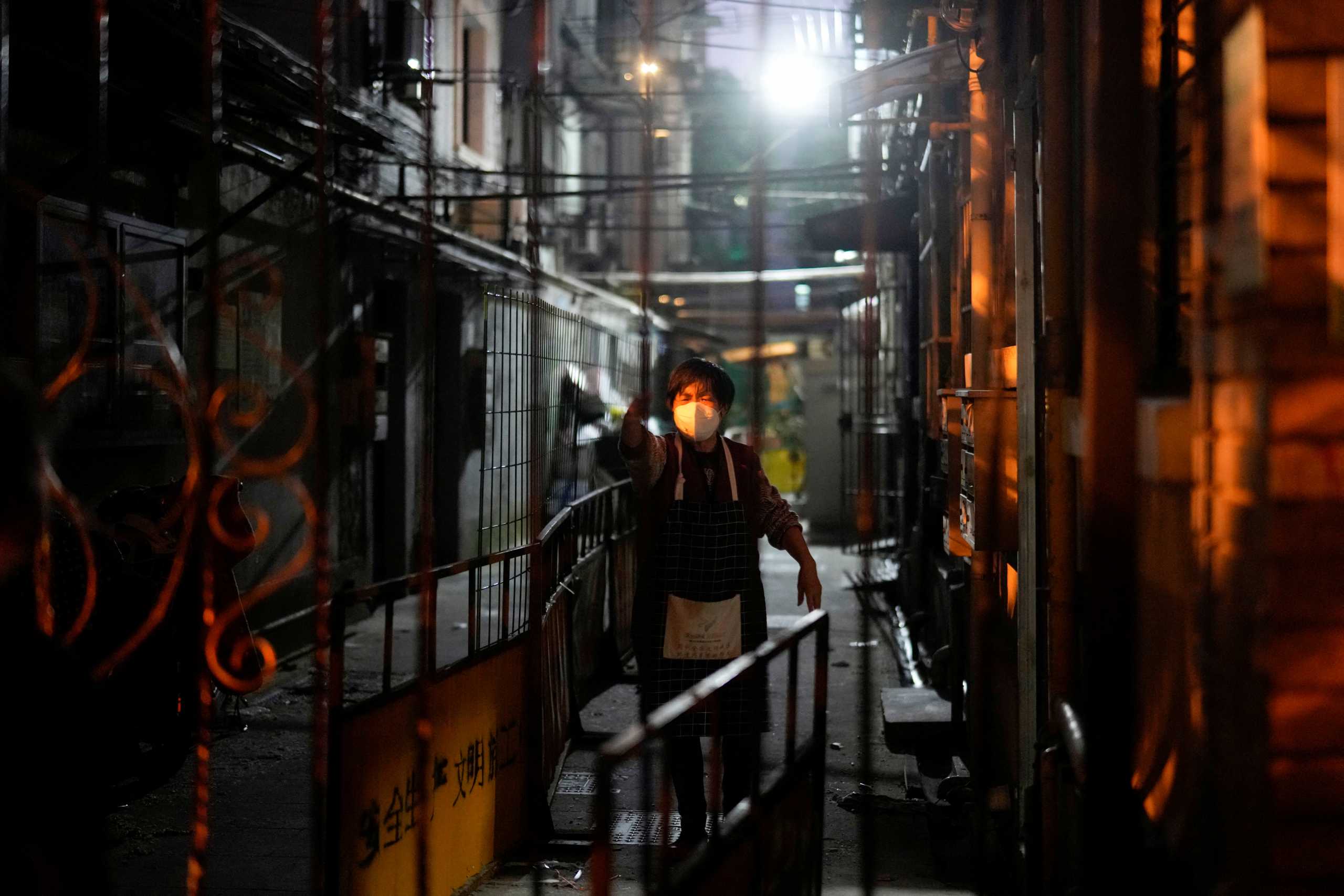 A resident is pictured behind barriers sealing off an area during lockdown, amid the coronavirus disease (COVID-19) pandemic, in Shanghai, China, May 3, 2022. REUTERS