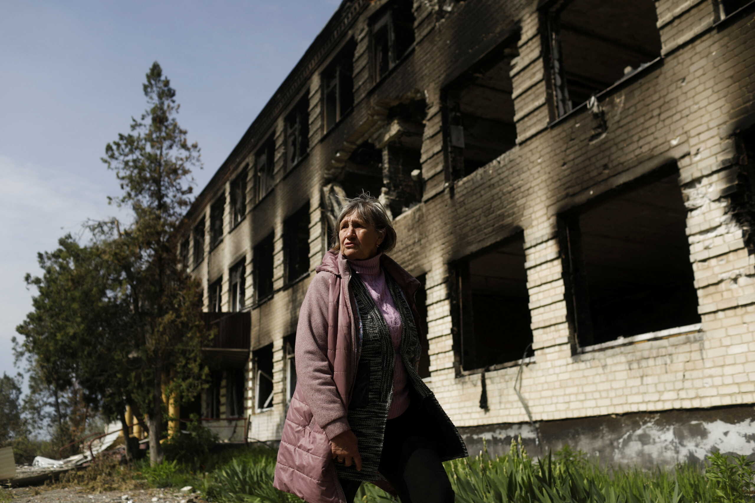 Lyubov Ivanivna reacts outside a damaged school where, according to residents, Russian soldiers were based before the Ukrainian Army retook the Vilhivka village, amid Russia's attack on Ukraine, near Kharkiv, Ukraine, May 11, 2022. REUTERS