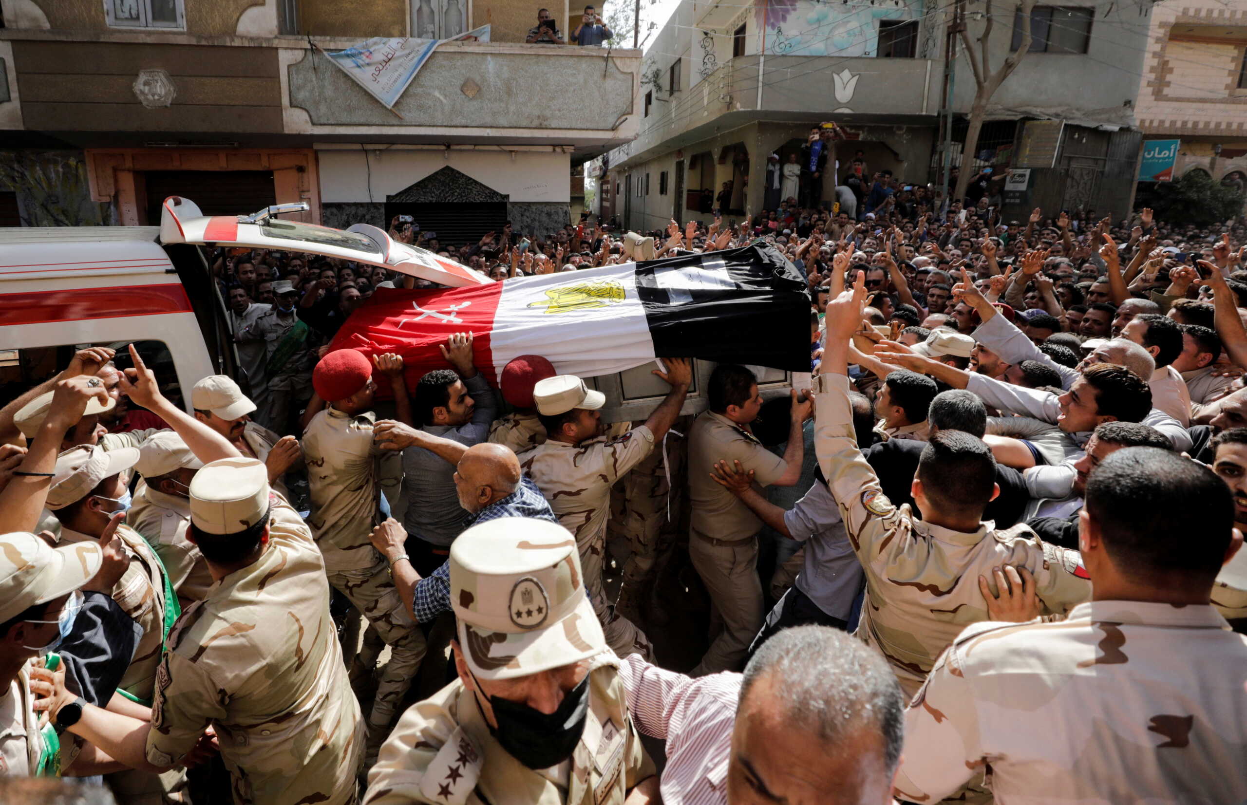 Mourners and soldiers carry the coffin containing the body of Egyptian officer Soleman Ali Soleman, who was killed in an armed attack claimed by Islamic State on Saturday in Egypt's Sinai peninsula, during a funeral at his home village Jazirat al-Ahrar, in Al Qalyubia Governorate, Egypt, May 9, 2022. REUTERS