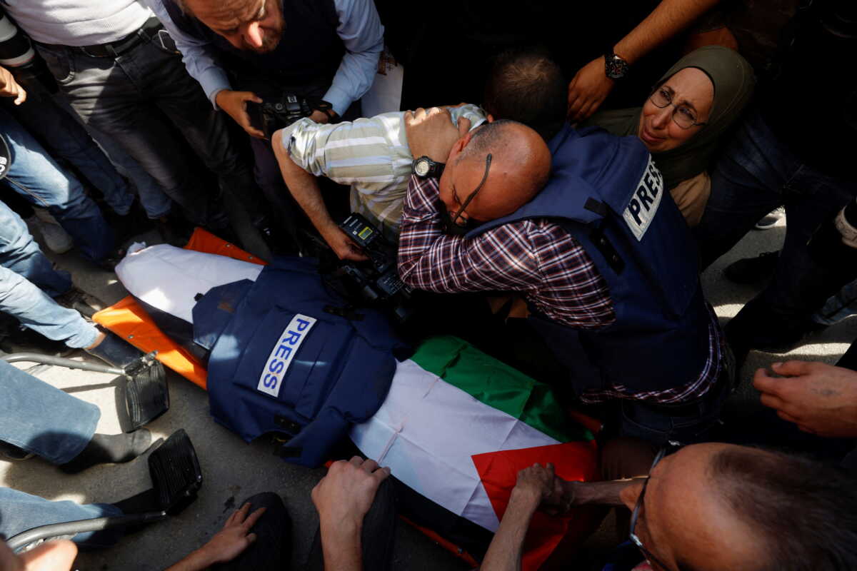 Journalists react next to the body of Al Jazeera reporter Shireen Abu Akleh, who was killed by Israeli army gunfire during an Israeli raid, according to the Qatar-based news channel, in Jenin in the Israeli-occupied West Bank May 11, 2022. Israeli military said Abu Akleh may have been shot by Palestinians as they clashed with its troops. REUTERS