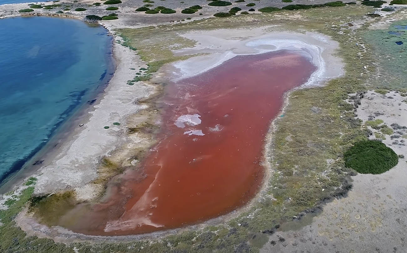 Το επίπεδο νησί της Ελλάδας σε σχήμα σπαθιού με την κόκκινη λίμνη με τα μυστηριώδη αρχικά
