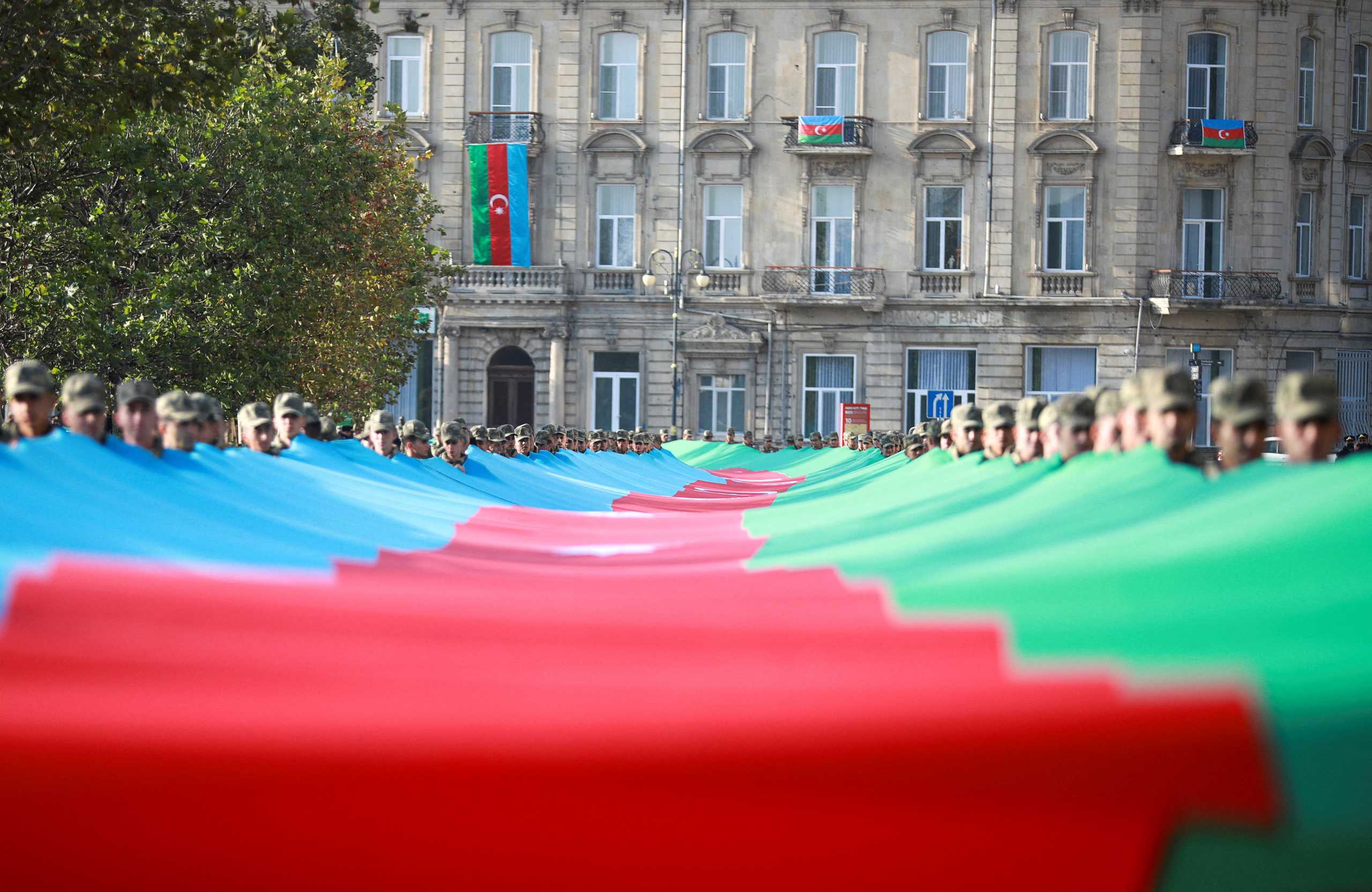 FILE PHOTO: Azeri service members carry a giant flag during a procession marking the anniversary of the end of the 2020 military conflict over Nagorno-Karabakh breakaway region, involving Azerbaijan's troops against ethnic Armenian forces, in Baku, Azerbaijan, November 8, 2021. REUTERS