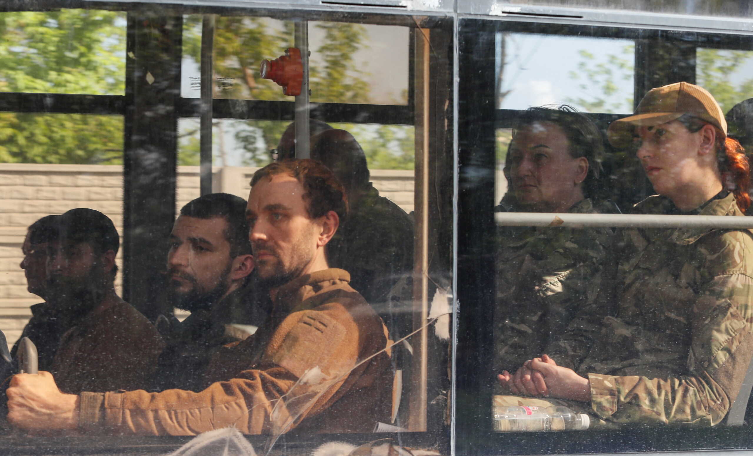 A bus carrying service members of the Ukrainian armed forces, who surrendered at the besieged Azovstal steel mill, drives away under escort of the pro-Russian military in the course of Ukraine-Russia conflict in Mariupol, Ukraine May 20, 2022. REUTERS
