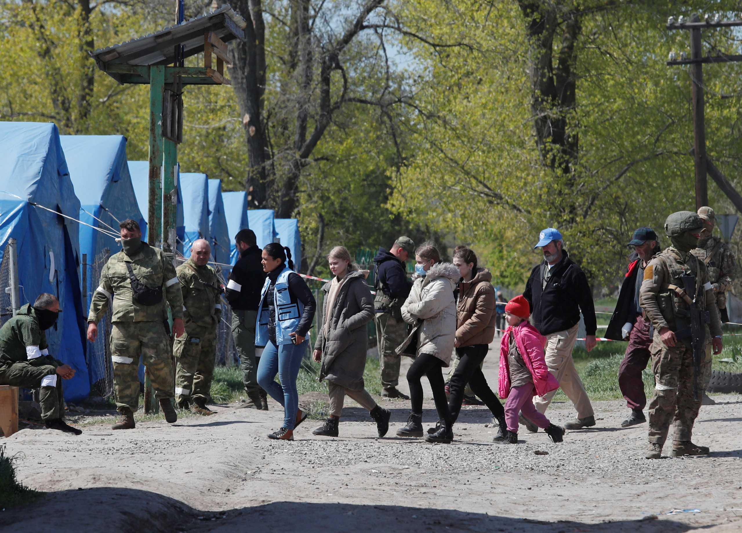 Civilians who left the area near Azovstal steel plant in Mariupol, accompanied by UN staff, walk at a temporary accommodation centre during Ukraine-Russia conflict in the village of Bezimenne in the Donetsk Region, Ukraine May 1, 2022. REUTERS