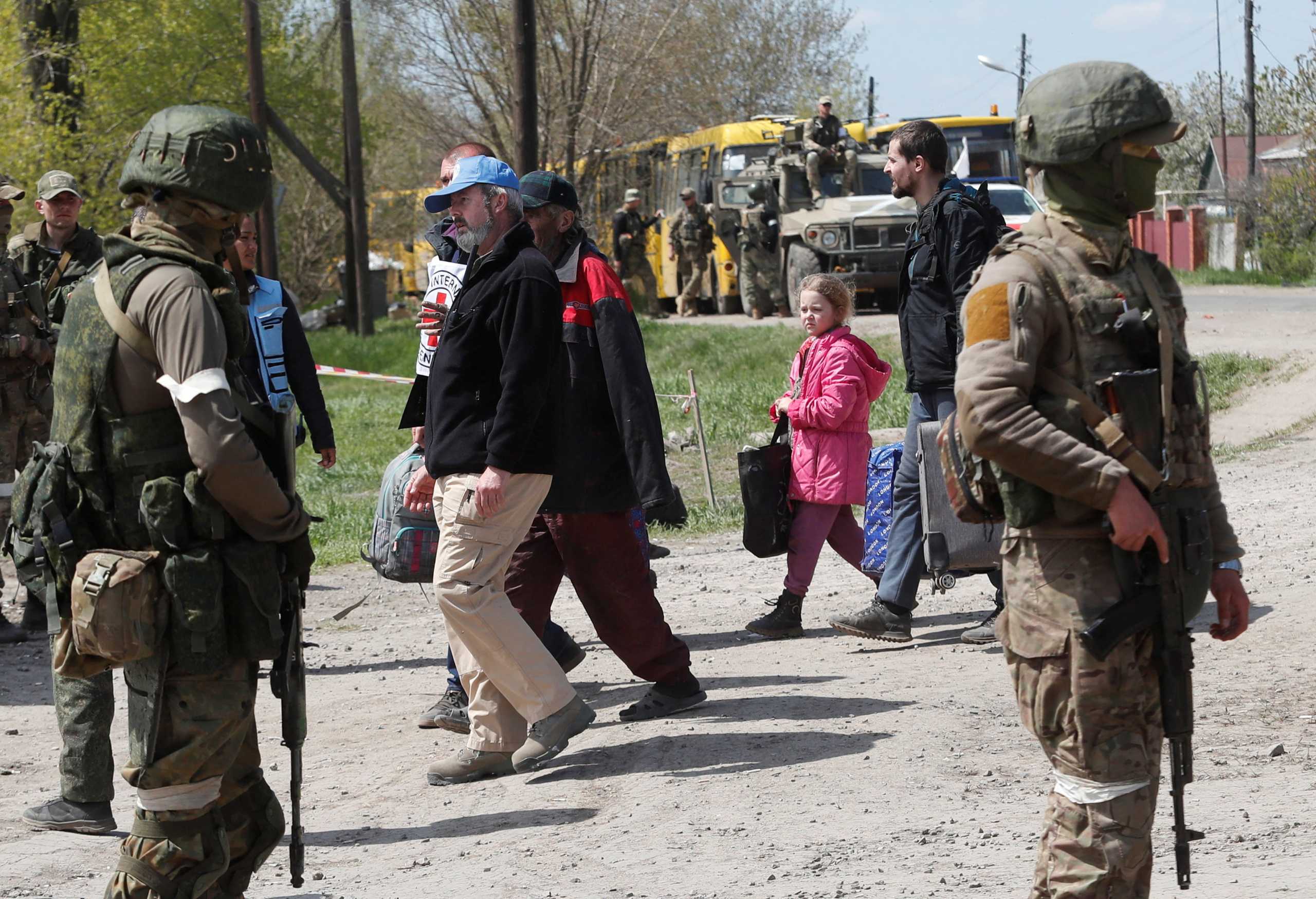 Civilians who left the area near Azovstal steel plant in Mariupol walk accompanied by UN staff and a member of the International Committee of the Red Cross (ICRC) at a temporary accommodation centre during Ukraine-Russia conflict in the village of Bezimenne in the Donetsk Region, Ukraine May 1, 2022. REUTERS