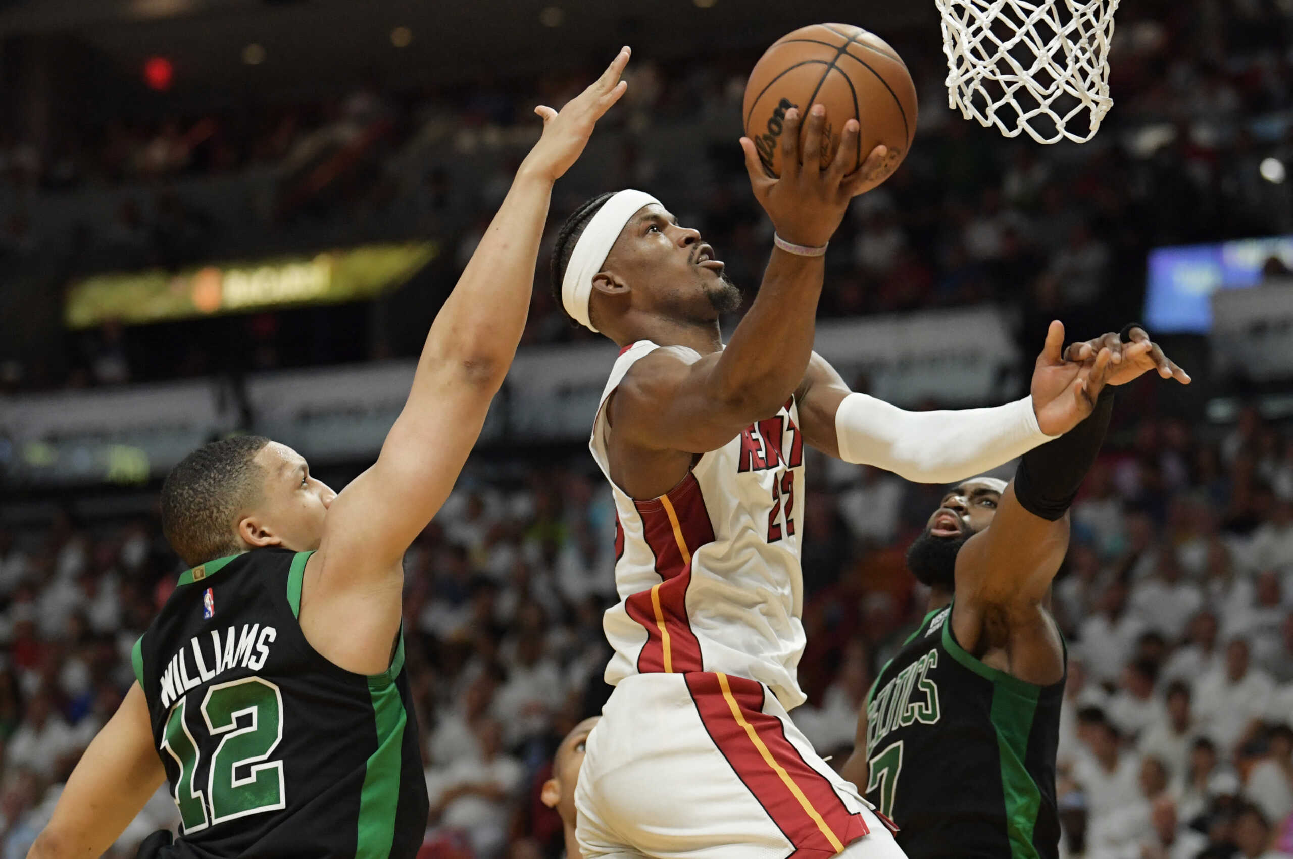 May 25, 2022; Miami, Florida, USA; Miami Heat forward Jimmy Butler (22) drives to the basket between Boston Celtics forward Grant Williams (12) and guard Jaylen Brown (7) during the fourth quarter of game five of the 2022 eastern conference finals at FTX Arena. Mandatory Credit: Jim Rassol-USA TODAY Sports