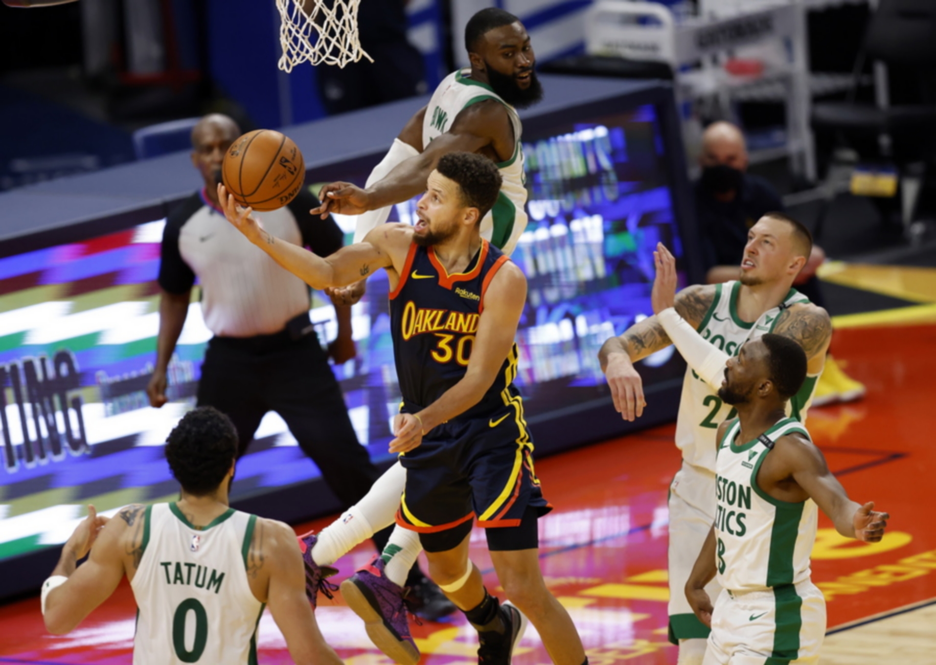 epaselect epa08983305 Golden State Warriors guard Stephen Curry (C) goes to the basket for two points while drawing a foul by Boston Celtics guard Jaylen Brown (back-C) during the second half of the NBA basketball game between the Boston Celtics and the Golden State Warriors at the Chase Center, in San Francisco, California, USA, 02 February 2021.  EPA