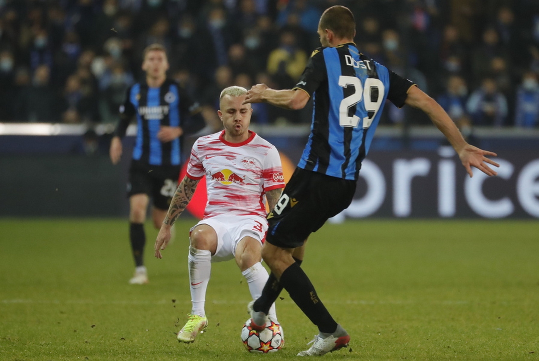 epa09601560 Angelino of RB Leipzig (L) and Bas Dost of Club Brugge (R) in action during the UEFA Champions League group A soccer match between Club Brugge and RB Leipzig in Bruges, Belgium, 24 November 2021.  EPA