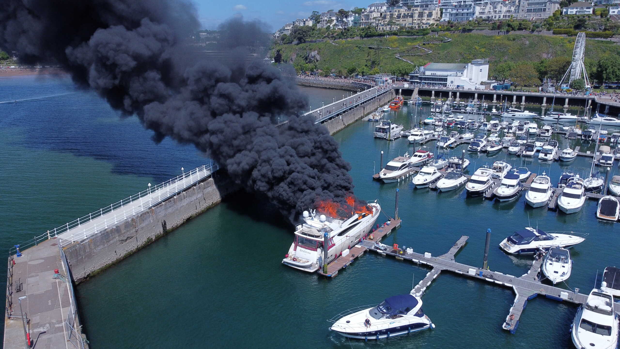Thick black smoke rises from a fire on a yacht, at Torquay harbour in Torquay, Britain May 28, 2022. Picture taken with a drone. Mike Trower
