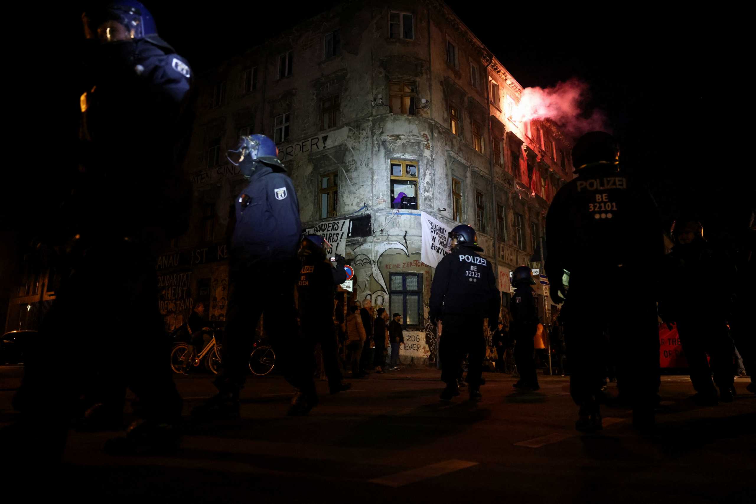 A person lights a flare in the "Linie206" building as demonstrators march in the protest "Take back the night", during the so-called Walpurgis Night ahead of May Day in Berlin, Germany, April 30, 2022. REUTERS