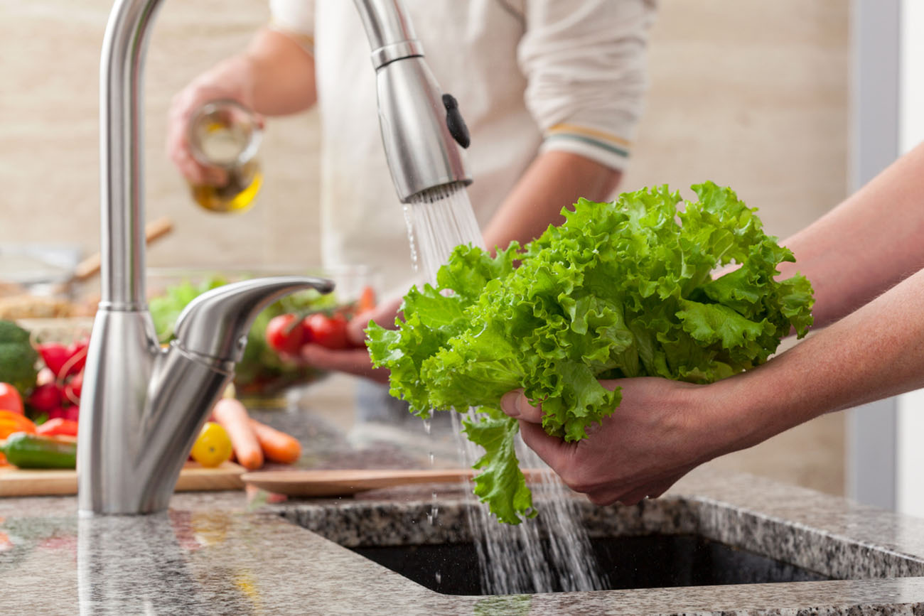 Washing fresh vegetables for a salad with an alive oil