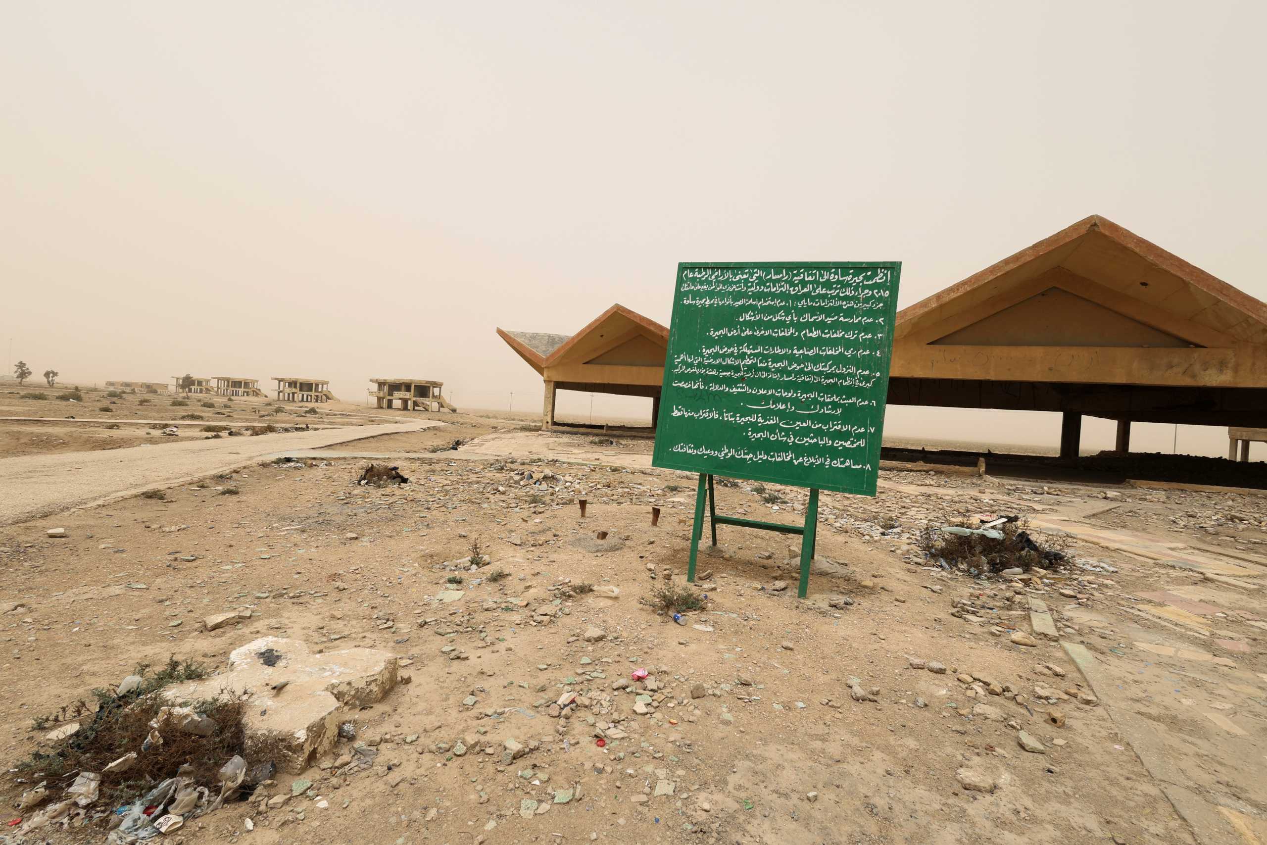 An information board is pictured near the pond remaining of Lake Sawa due to climate change-induced drought, in Samawa city, Iraq May 1, 2022. Picture taken May 1, 2022 . REUTERS