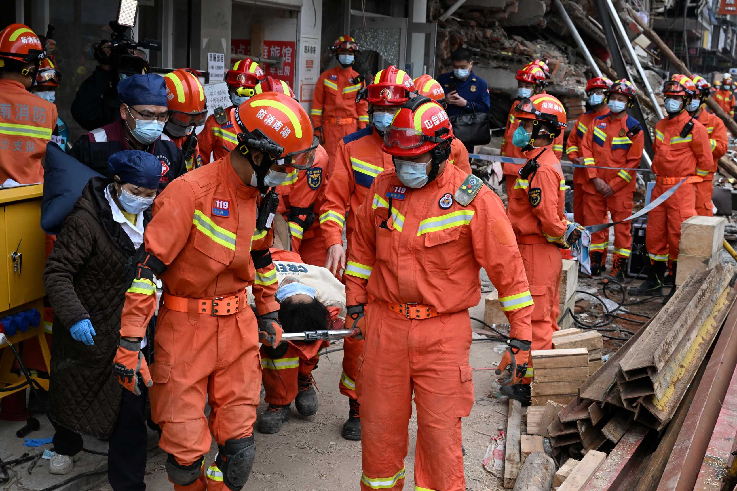 Rescue workers carry an injured person on a stretcher at a site where a building collapsed in Changsha, Hunan province, China May 1, 2022. China Daily