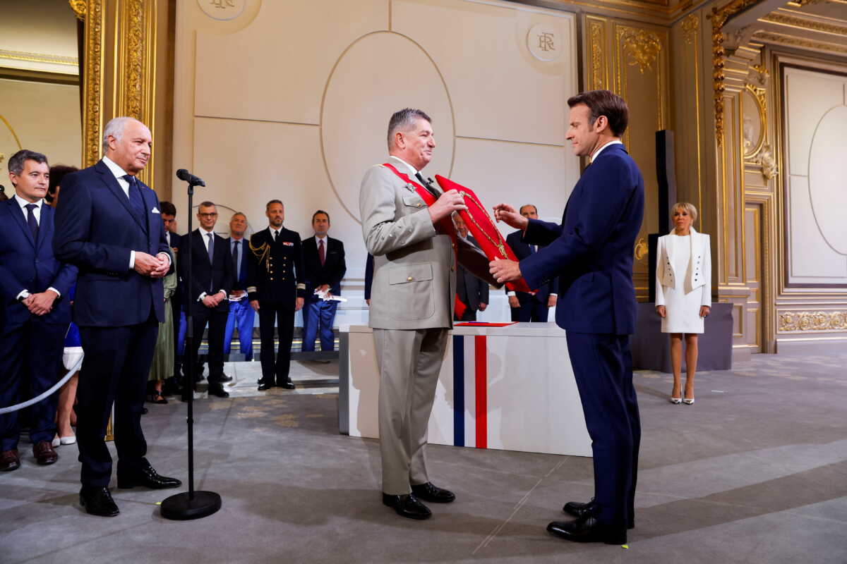 Laurent Fabius, President of the French Constitutional Council stands in front of France's Military Chief of Staff to the presidency Benoit Puga and French President Emmanuel Macron as he is sworn-in for a second term as president after his re-election, during a ceremony at the Elysee Palace in Paris, France, May 7, 2022. REUTERS