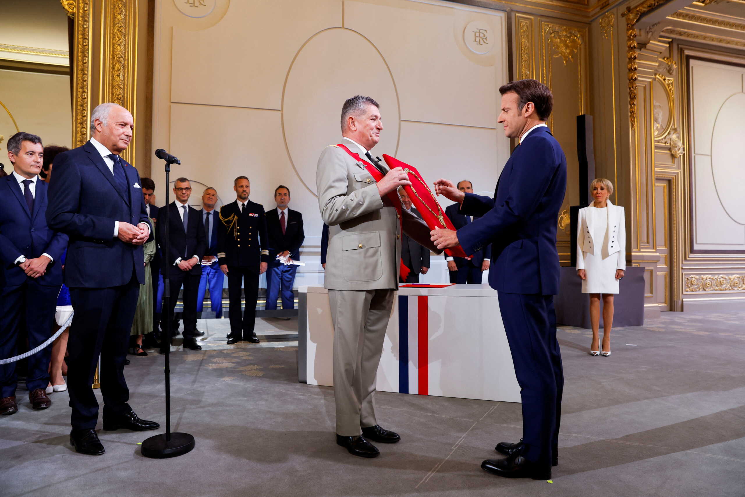 Laurent Fabius, President of the French Constitutional Council stands in front of France's Military Chief of Staff to the presidency Benoit Puga and French President Emmanuel Macron as he is sworn-in for a second term as president after his re-election, during a ceremony at the Elysee Palace in Paris, France, May 7, 2022. REUTERS