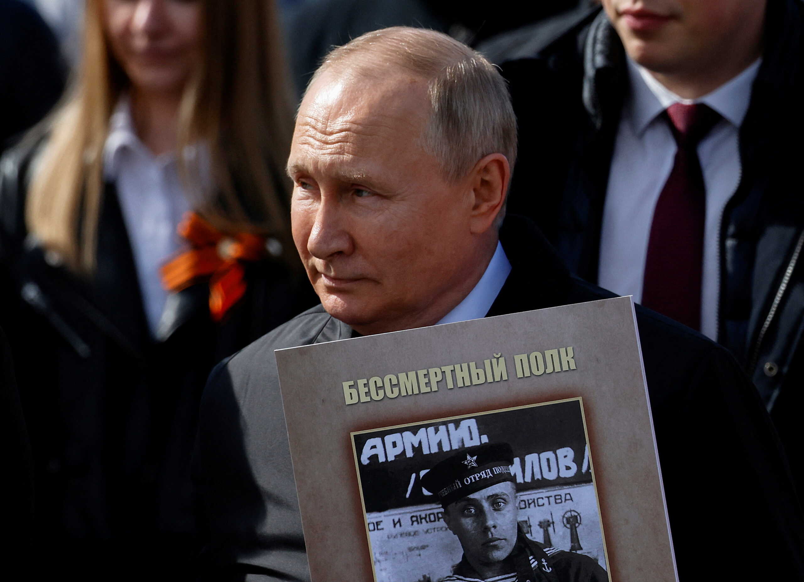 Russian President Vladimir Putin holds a portrait of his father, war veteran Vladimir Spiridonovich Putin, as he takes part in the Immortal Regiment march on Victory Day, which marks the 77th anniversary of the victory over Nazi Germany in World War Two, in central Moscow, Russia May 9, 2022. REUTERS