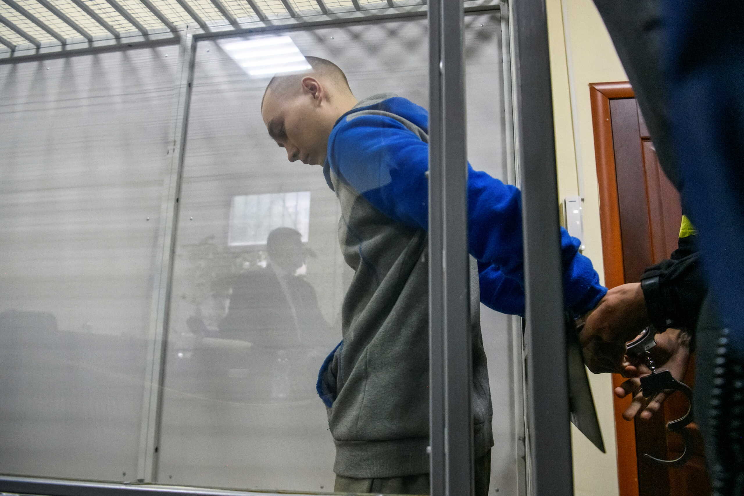 Russian soldier Vadim Shishimarin, 21, suspected of violations of the laws and norms of war, is seen inside a defendants' cage during a court hearing, amid Russia's invasion of Ukraine, in Kyiv, Ukraine May 18, 2022.  REUTERS
