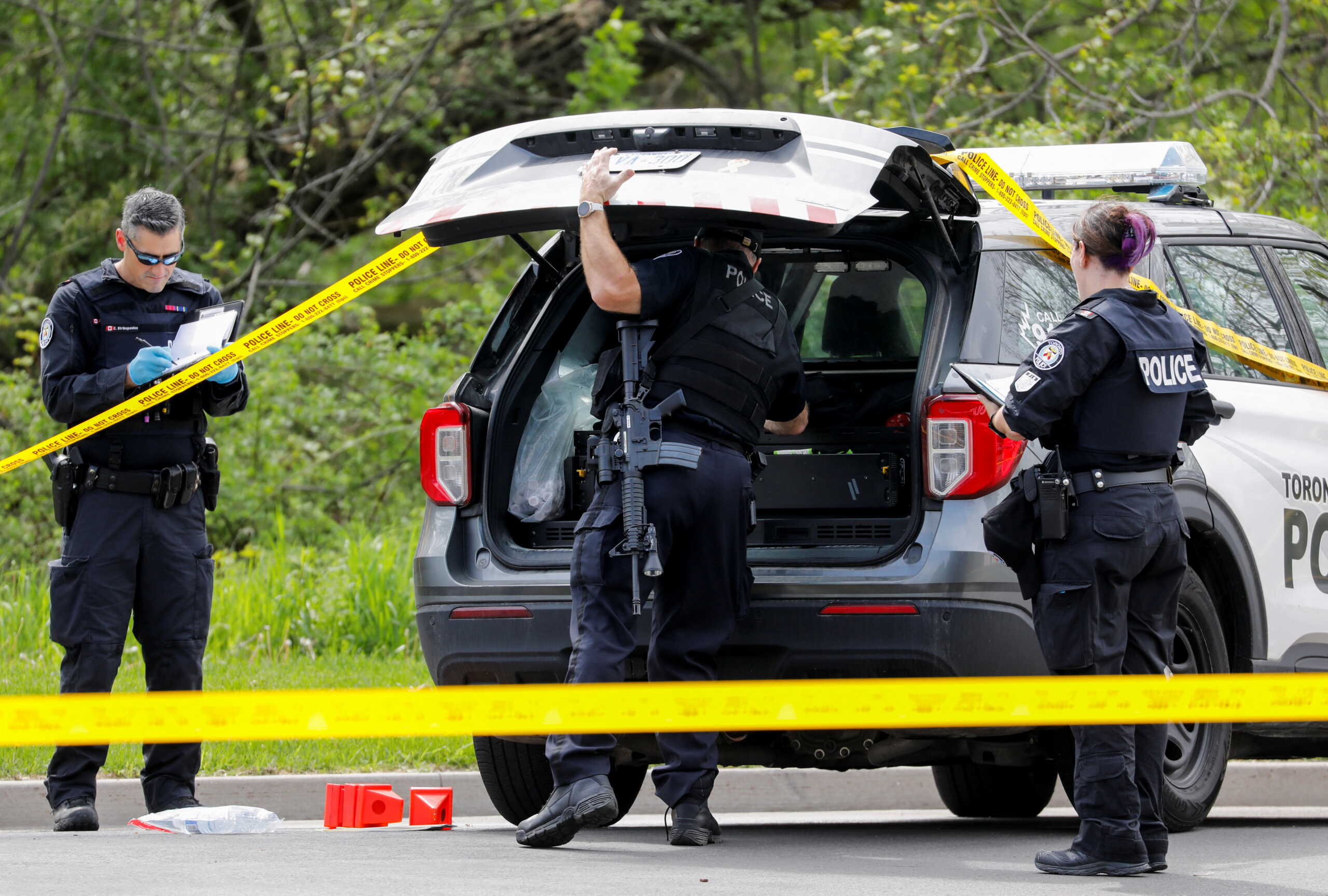 Police officers work at the scene where police shot and injured a suspect who was walking down a city street carrying a gun, as four nearby schools were placed on lockdown, in Toronto, Ontario, Canada, May 26, 2022. REUTERS
