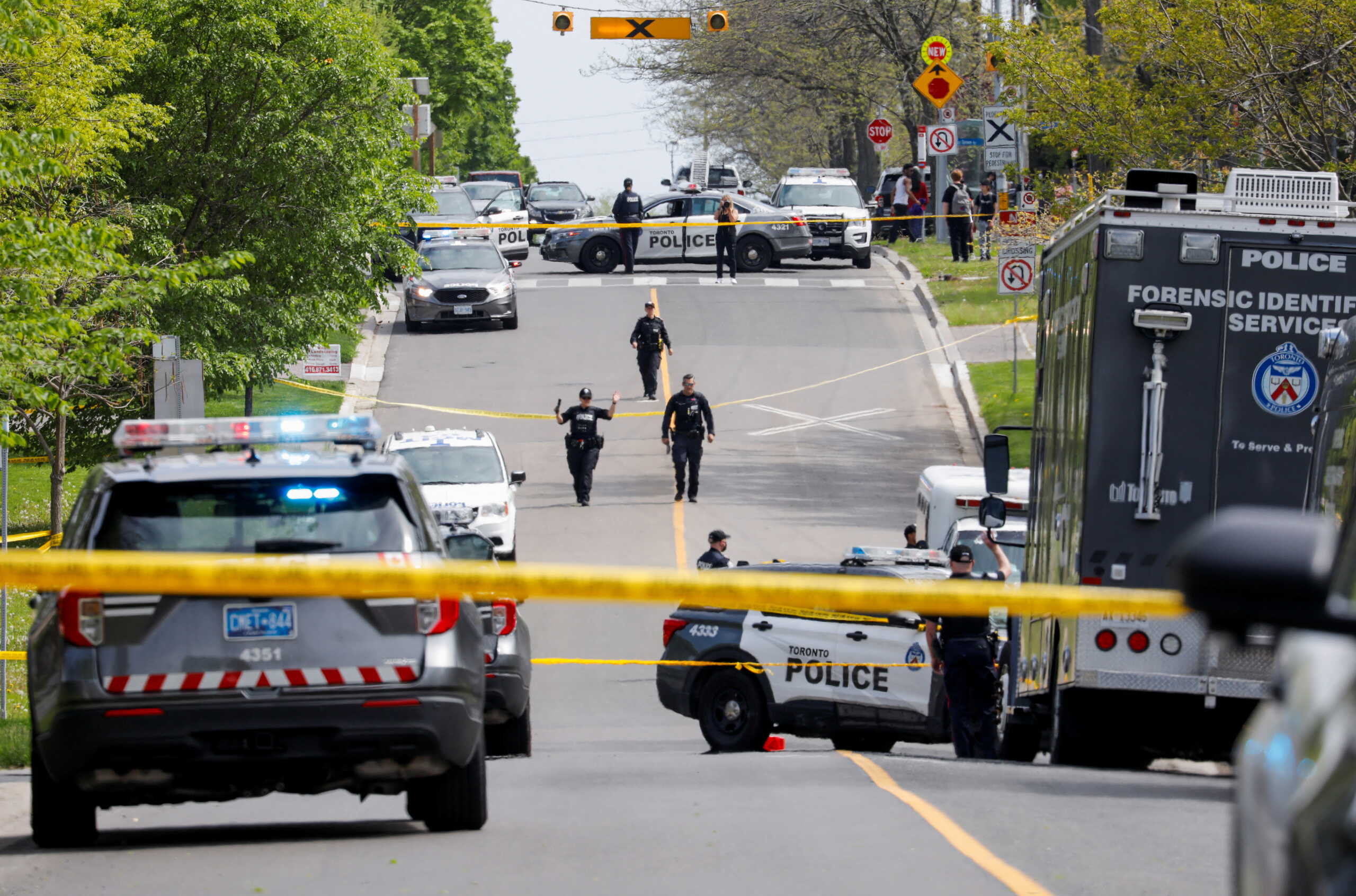 Police officers work at the scene where police shot and injured a suspect who was walking down a city street carrying a gun, as four nearby schools were placed on lockdown, in Toronto, Ontario, Canada, May 26, 2022. REUTERS