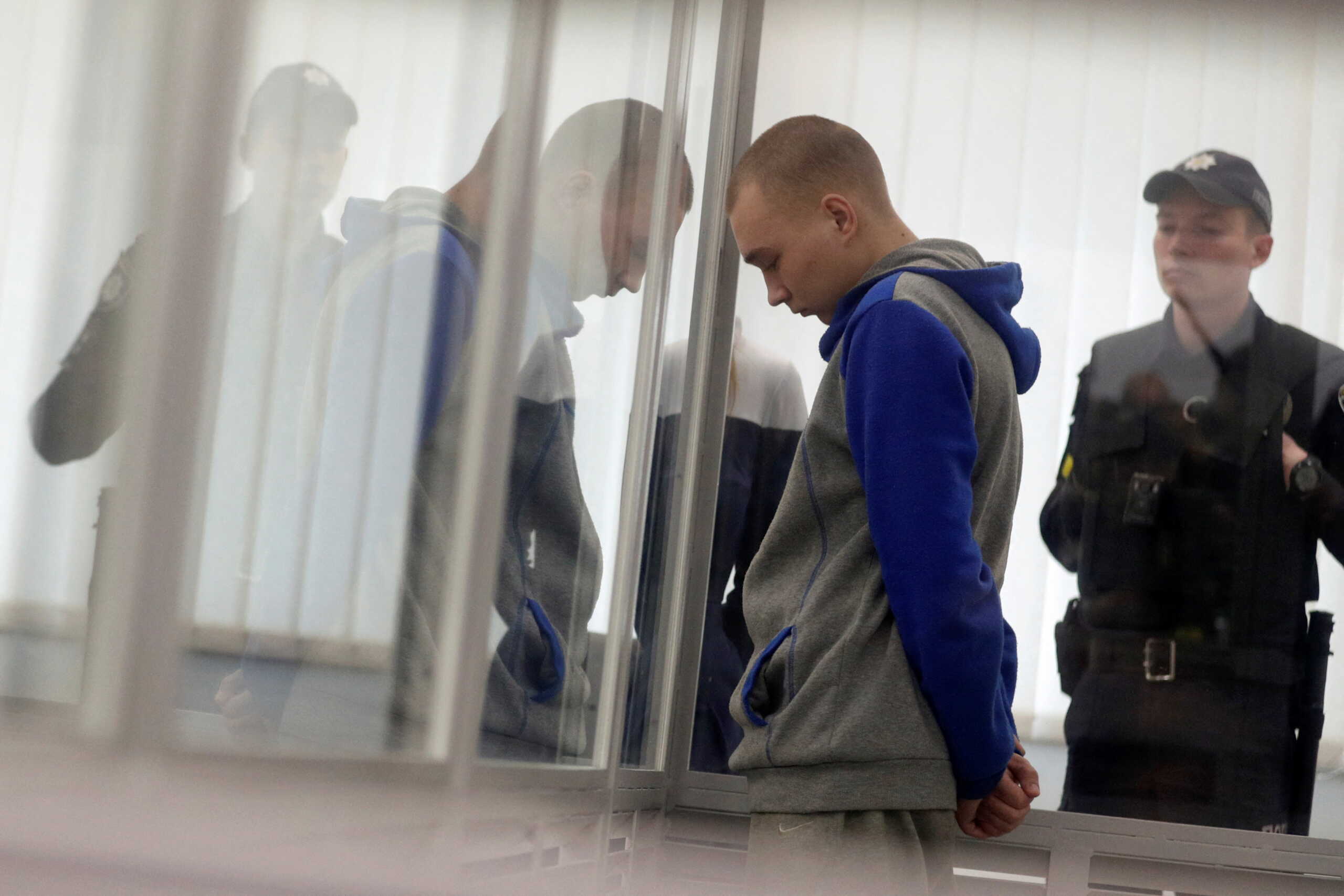 Russian soldier Vadim Shishimarin, 21, suspected of violations of the laws and norms of war, stands inside a cage during a court hearing, amid Russia's invasion of Ukraine, in Kyiv, Ukraine May 23, 2022. REUTERS