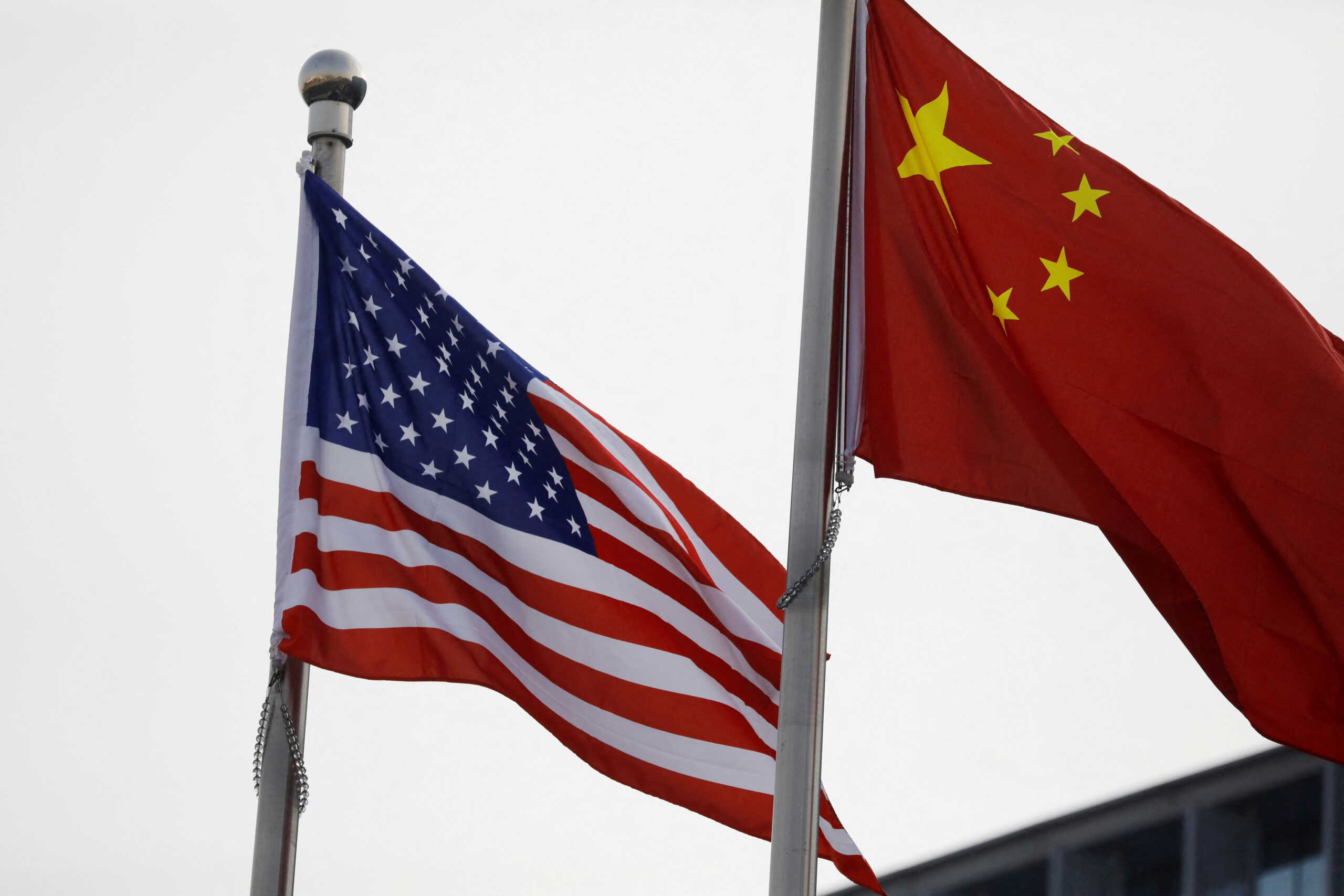 FILE PHOTO: Chinese and U.S. flags flutter outside the building of an American company in Beijing, China January 21, 2021. REUTERS