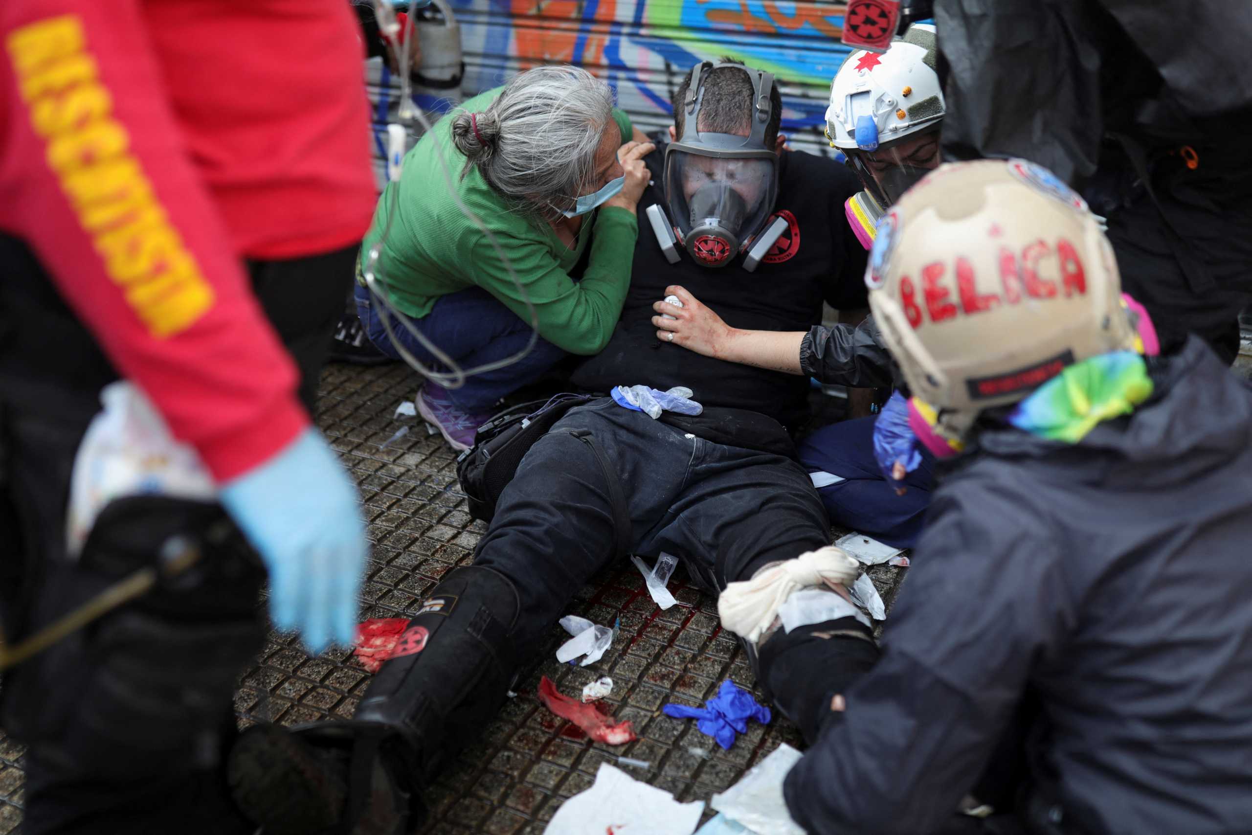 An injured first aid volunteer receives medical attention during the May Day rally in Santiago, Chile May 1, 2022. REUTERS