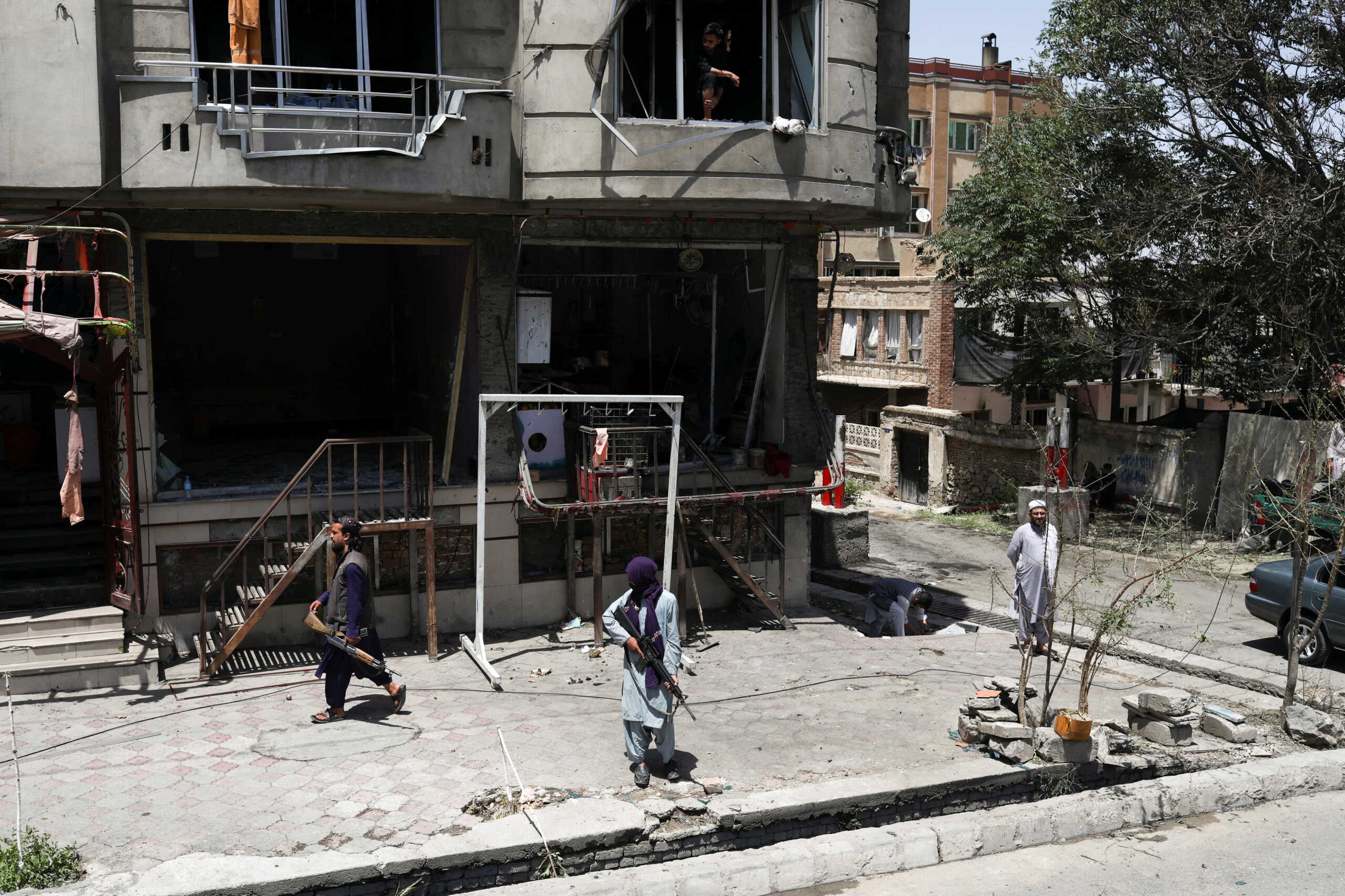 Taliban fighters stand guard at the site where an explosive-laden vehicle detonated amidst an attack on a Sikh Temple in Kabul, Afghanistan, June 18, 2022. REUTERS