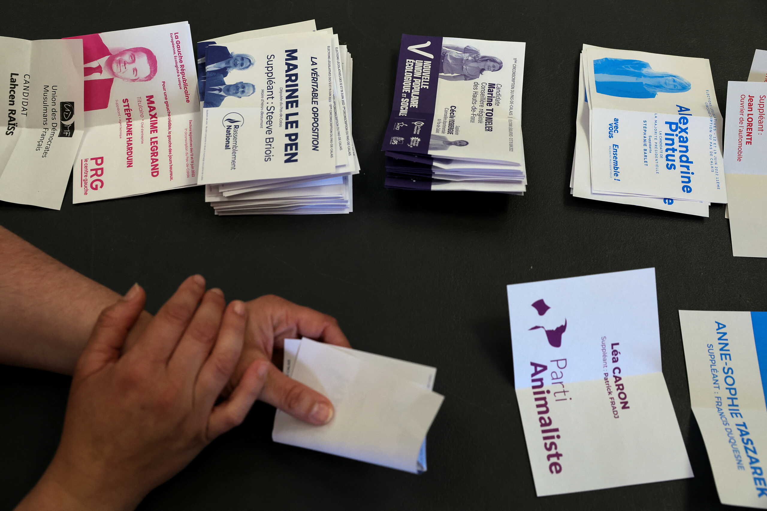 An official counts ballots for the first round of French parliamentary elections, at a polling station in Henin-Beaumont, France, June 12, 2022. REUTERS