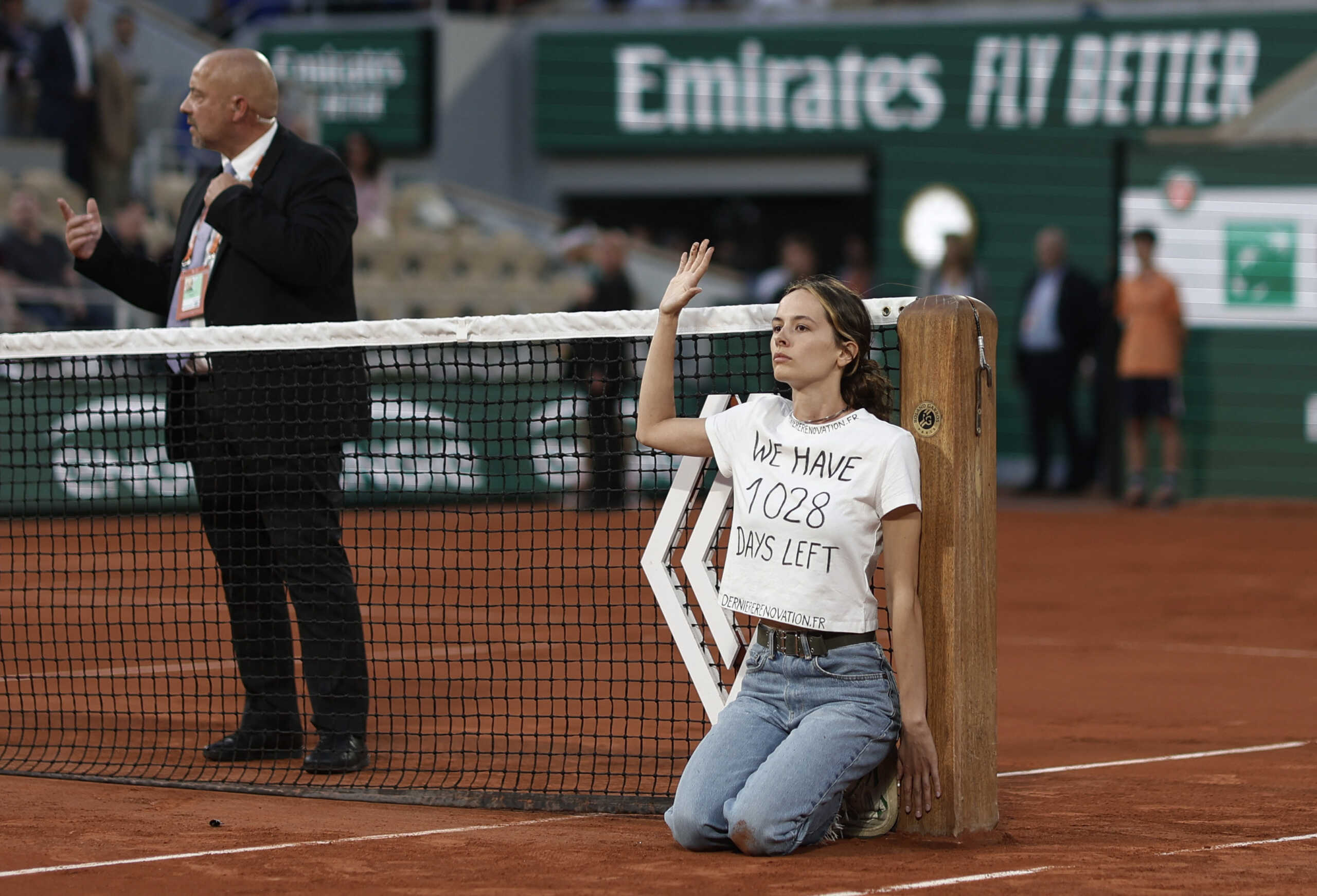 Tennis - French Open - Roland Garros, Paris, France - June 3, 2022 Protestor ties herself to the net during the semi final between Norway's Casper Ruud and Croatia's Marin Cilic REUTERS