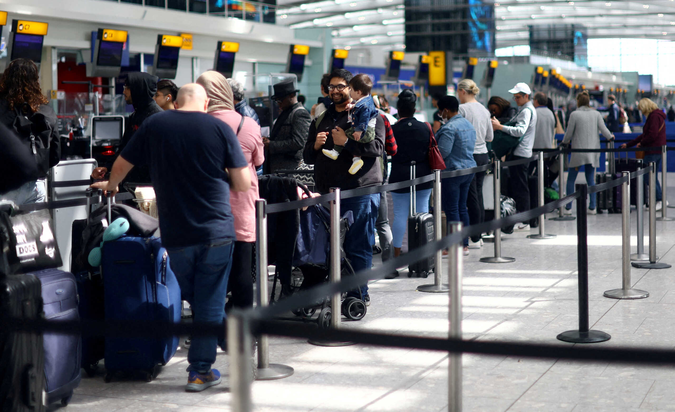 FILE PHOTO: Passengers queue for check-in desks at Heathrow airport's Terminal 5 in London, Britain, June 1, 2022.REUTERS