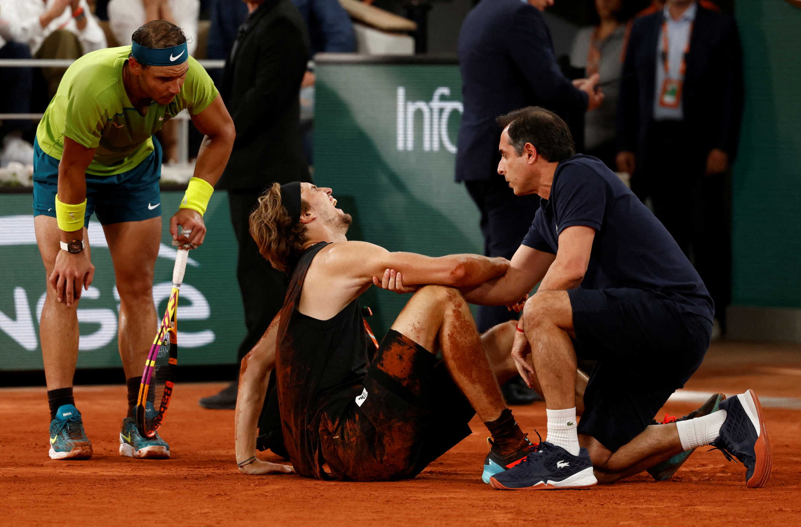 Tennis - French Open - Roland Garros, Paris, France - June 3, 2022 Germany's Alexander Zverev receives medical attention after sustaining an injury as Spain's Rafael Nadal looks on REUTERS