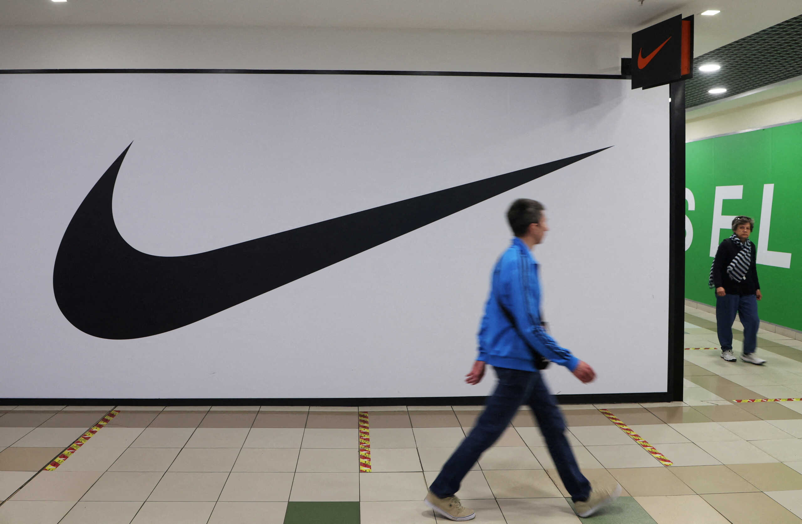 FILE PHOTO: People walk past a closed store of the sporting goods retailer Nike at a shopping mall in Saint Petersburg, Russia May 25, 2022. REUTERS