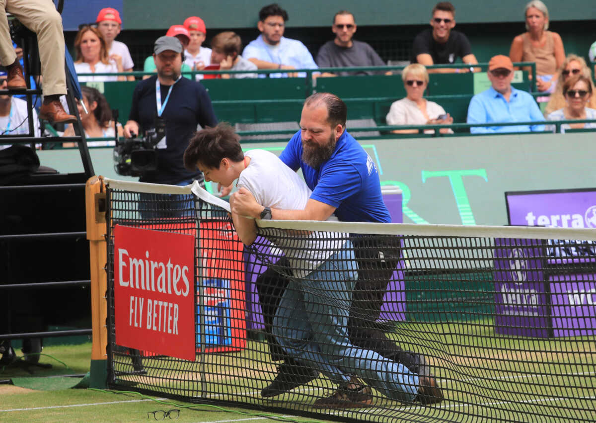 Tennis - ATP 500 - Halle Open - Gerry Weber Stadion, Halle, Germany - June 19, 2022 A pitch invader is detained by security during the final match between Russia's Daniil Medvedev and Poland's Hubert Hurkacz REUTERS